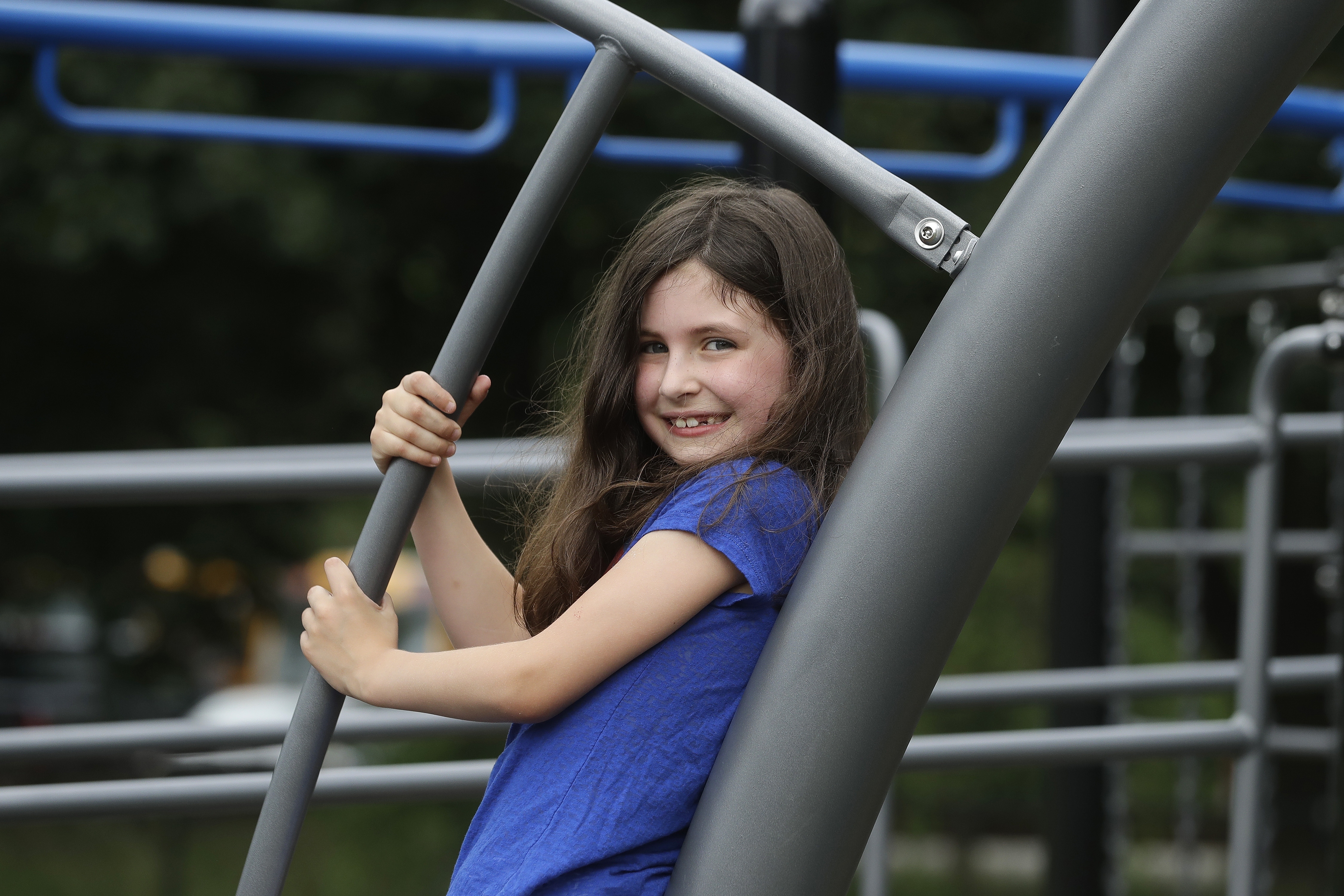 Sophia Garabedian, 6, of Sudbury, Massachusetts, who contracted Eastern Equine Encephalitis in 2019, stands for a photograph on a playground on July 8, 2020, in Sudbury. (AP Photo/Steven Senne)