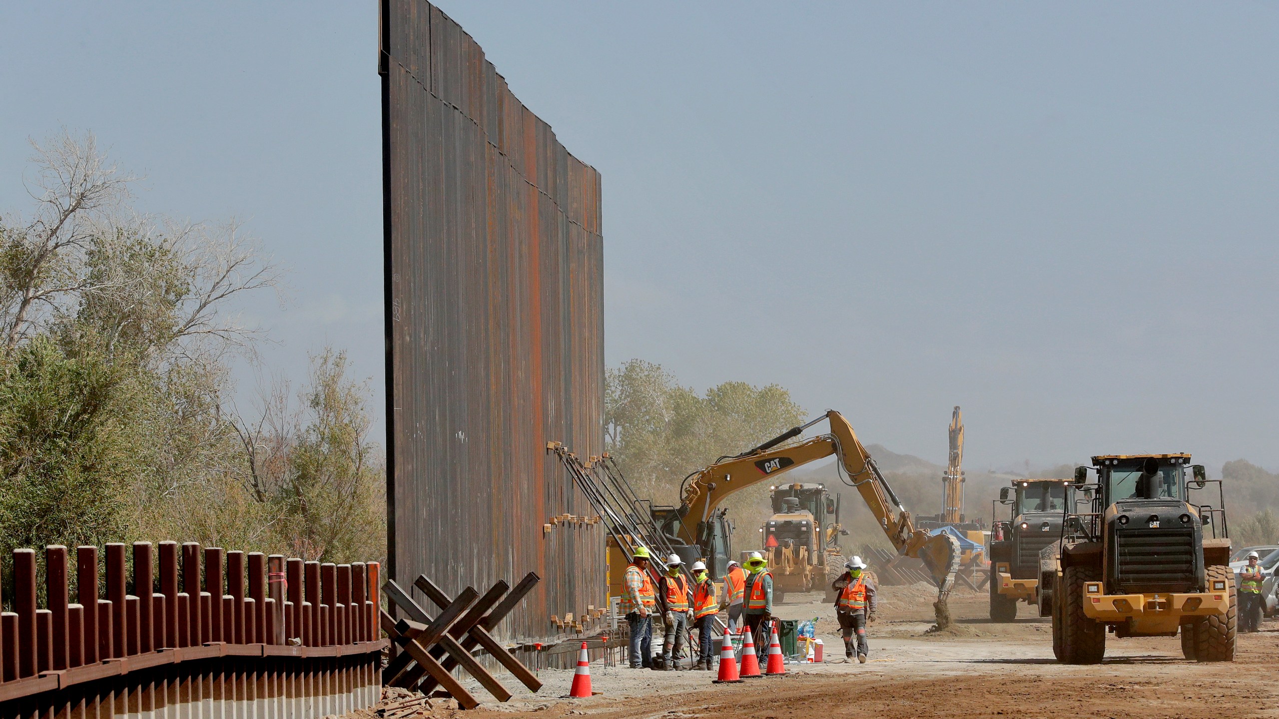 In this Sept. 10, 2019, file photo, government contractors erect a section of Pentagon-funded border wall along the Colorado River in Yuma, Arizona. (Matt York / Associated Press)