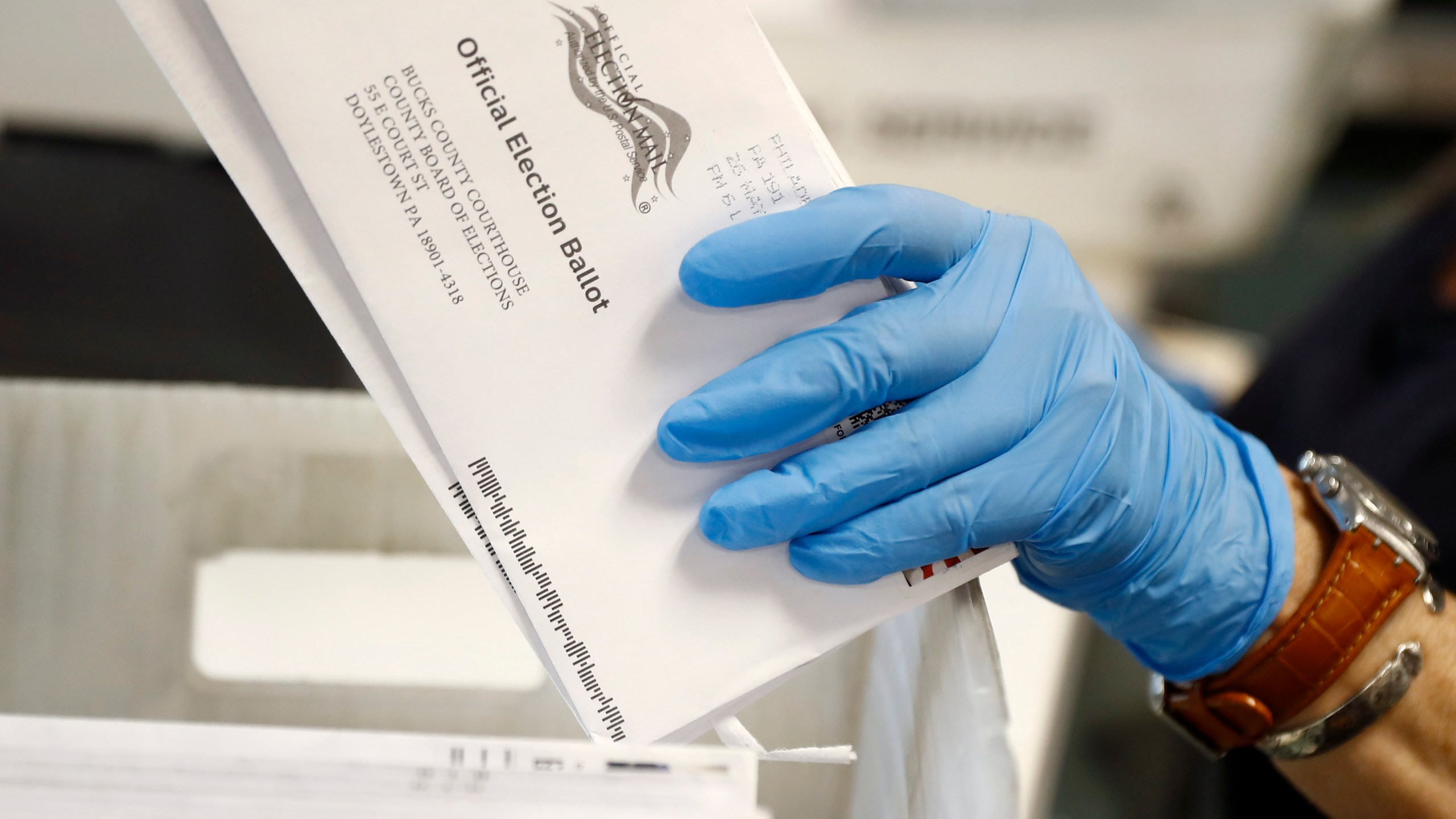 In this May 27, 2020 file photo, a worker processes mail-in ballots at the Bucks County Board of Elections office prior to the primary election in Doylestown, Pa. (AP Photo/Matt Slocum, File)