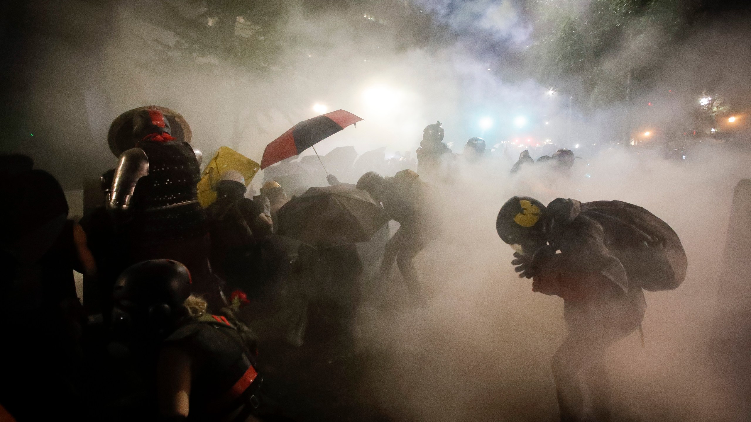 Federal officers launch tear gas at a group of demonstrators during a Black Lives Matter protest at the Mark O. Hatfield United States Courthouse Sunday, July 26, 2020, in Portland, Ore. (AP Photo/Marcio Jose Sanchez)