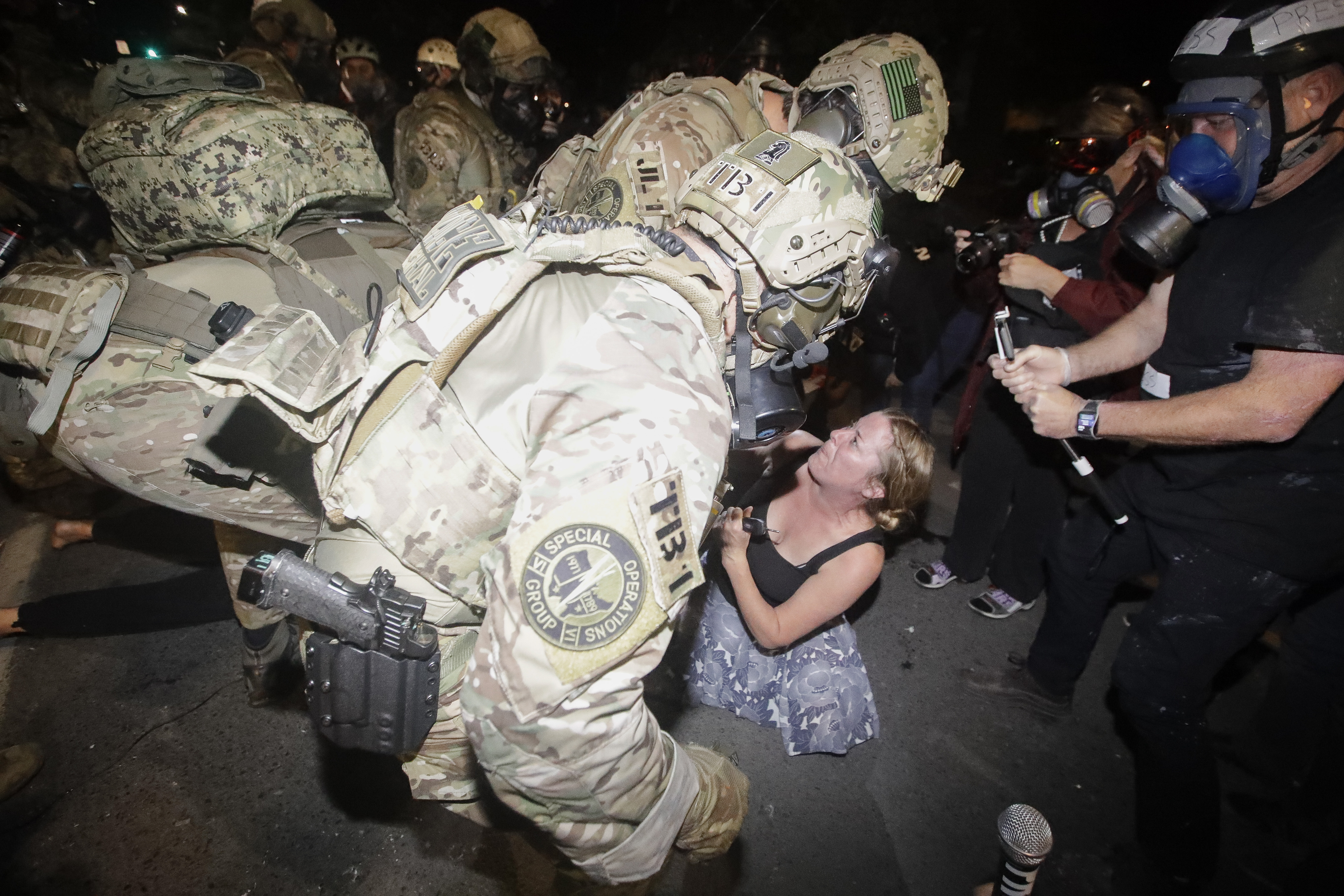 A demonstrator is charged by federal officers during a Black Lives Matter protest at the Mark O. Hatfield United States Courthouse Monday, July 27, 2020, in Portland, Ore. (AP Photo/Marcio Jose Sanchez)