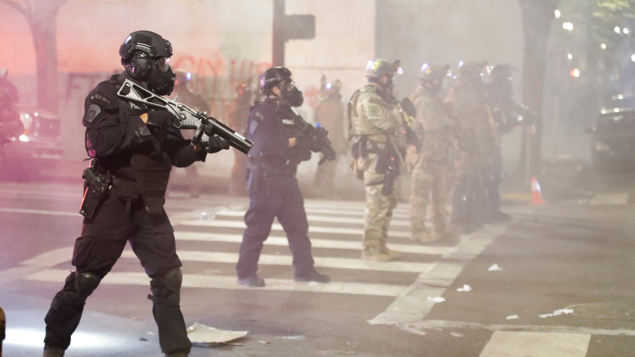 Federal officers deploy tear gas and crowd control munitions at demonstrators during a Black Lives Matter protest at the Mark O. Hatfield United States Courthouse Tuesday, July 28, 2020, in Portland, Ore. (AP Photo/Marcio Jose Sanchez)