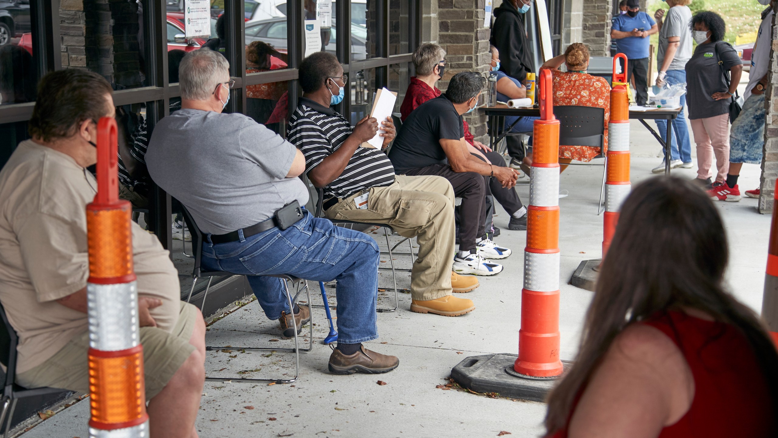 In this July 15, 2020, file photo, job seekers exercise social distancing as they wait to be called into the Heartland Workforce Solutions office in Omaha, Neb. A Republican proposal to slash the $600 weekly benefit boost for those left jobless because of the coronavirus shutdown could result in weeks or even months of delayed payments in some states. (AP Photo/Nati Harnik, File)