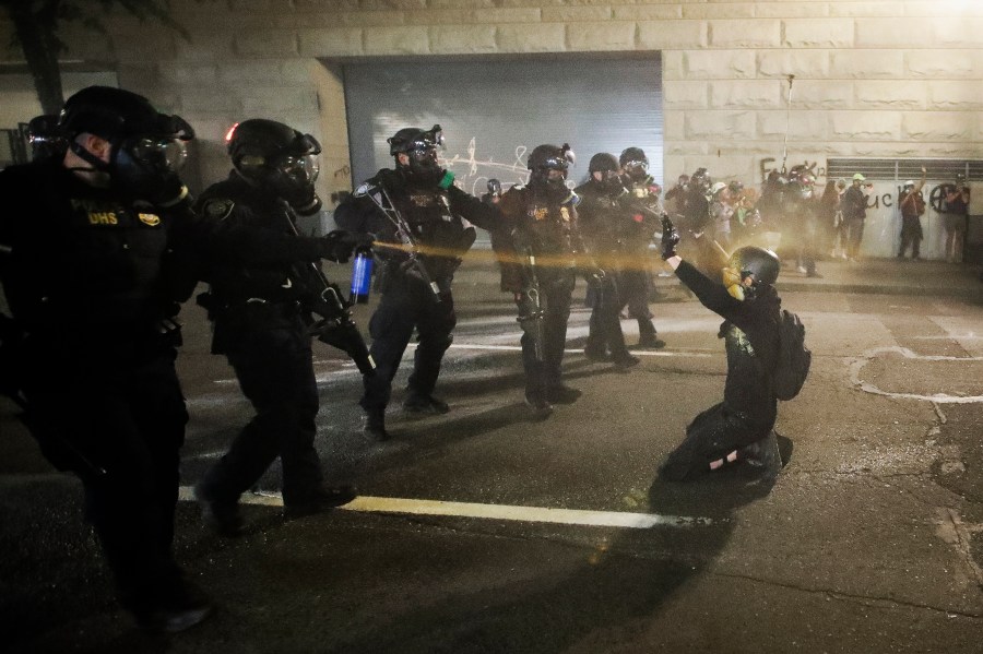 A demonstrator is pepper sprayed shortly before being arrested during a Black Lives Matter protest at the Mark O. Hatfield United States Courthouse Wednesday, July 29, 2020, in Portland, Ore. (Marcio Jose Sanchez)