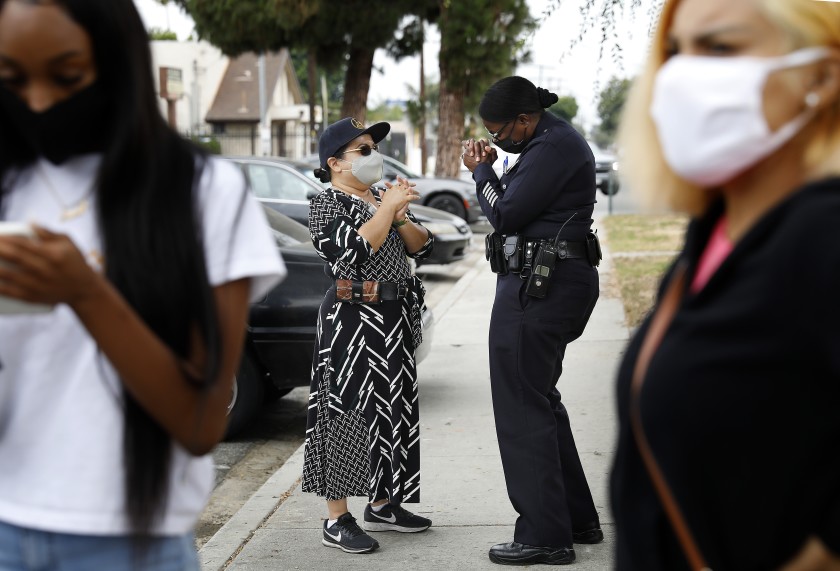 Emada Tingirides, deputy chief of the LAPD’s new community policing bureau, chats with Augie Lopez of the city’s Housing Authority at Nickerson Gardens in Watts in this undated photo. (Christina House / Los Angeles Times)