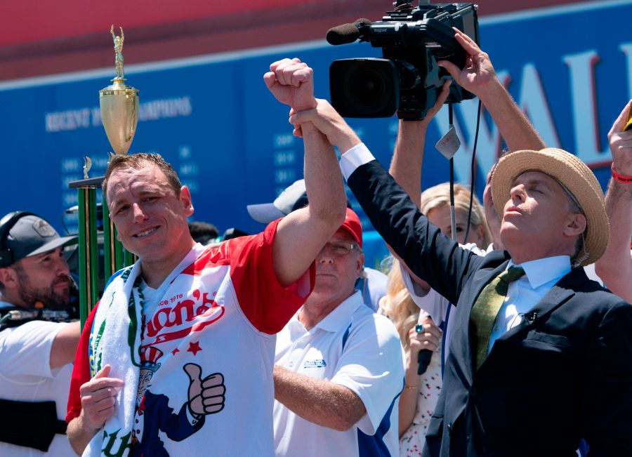 Joey Chestnut (L) has his arm raised in the air by George Shea after Chestnut won the 2019 Nathan's Famous Fourth of July hot dog eating contest on Coney Island on July 4, 2019 in New York. (DON EMMERT/AFP via Getty Images)