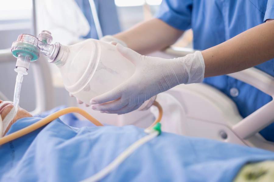 This file photo shows a doctor holding an oxygen Ambu bag over a patient given oxygen by intubation tube in an ICU. (Getty Images)