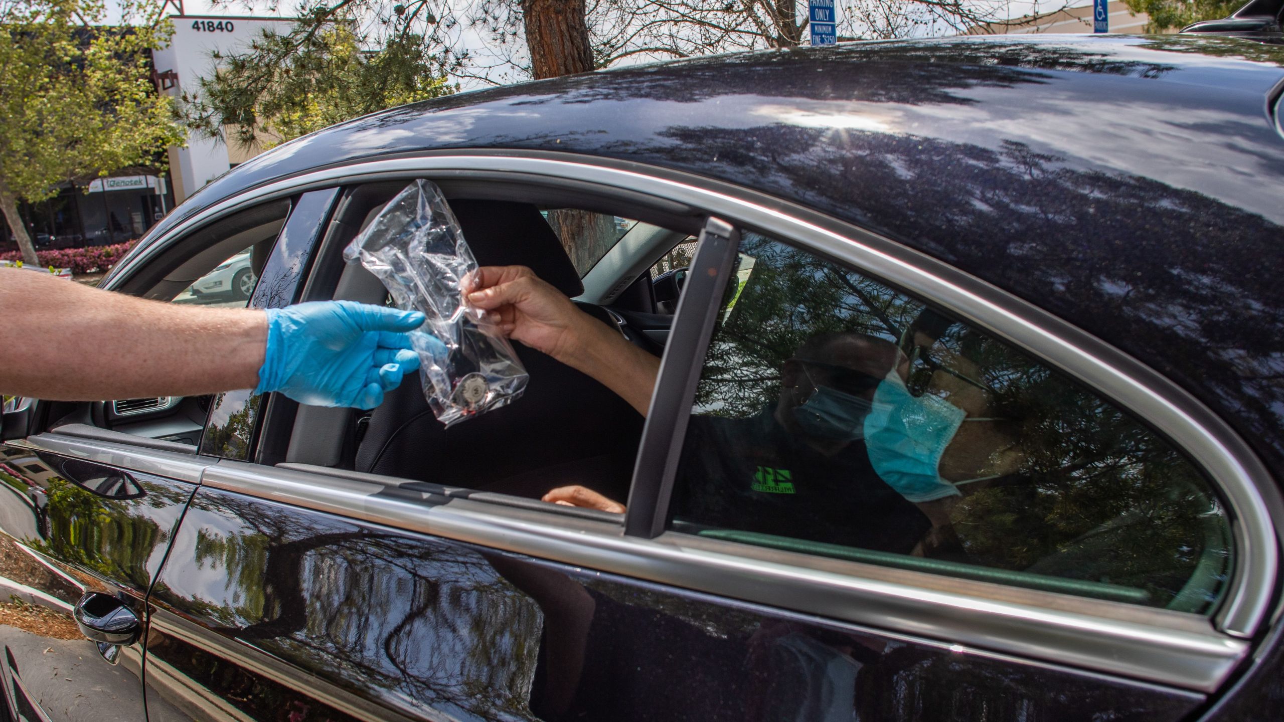 Worshippers are given communion inside their car while Pastor Tim Thompson leads an on-line Sunday Service in the Christian '412 Church Murrieta' parking lot on April 19, 2020 in Murietta, California. (Photo by APU GOMES/AFP via Getty Images)