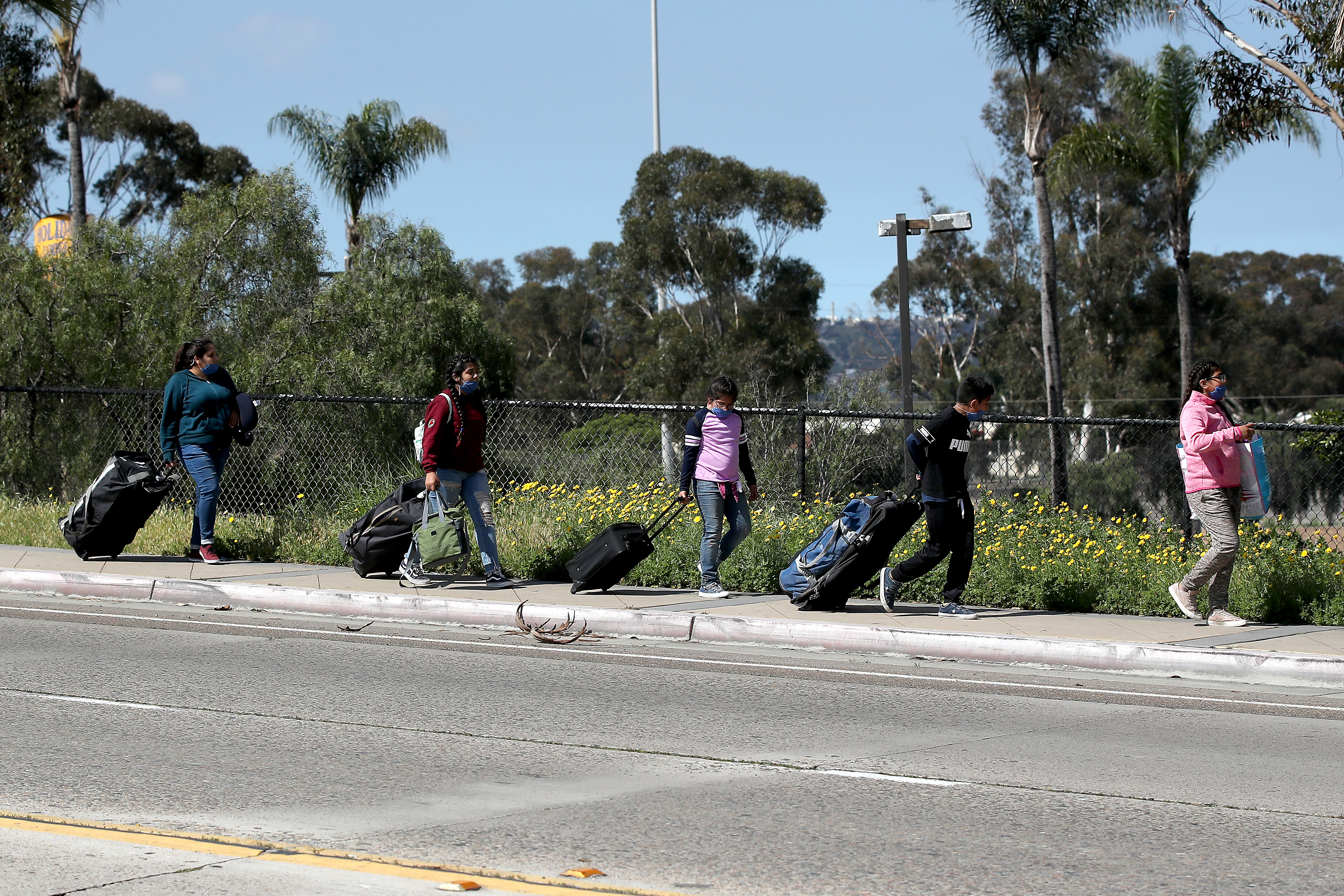 A family walks towards the U.S. Customs and Border Protection at the San Ysidro Port of Entry on March 21, 2020 in San Diego. (Sean M. Haffey/Getty Images)