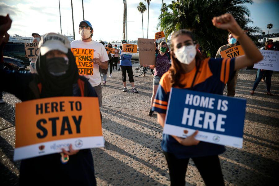 People hold signs during a rally in support of the Supreme Court's ruling in favor of the Deferred Action for Childhood Arrivals (DACA) program, in San Diego on June 18, 2020. (SANDY HUFFAKER/AFP via Getty Images)