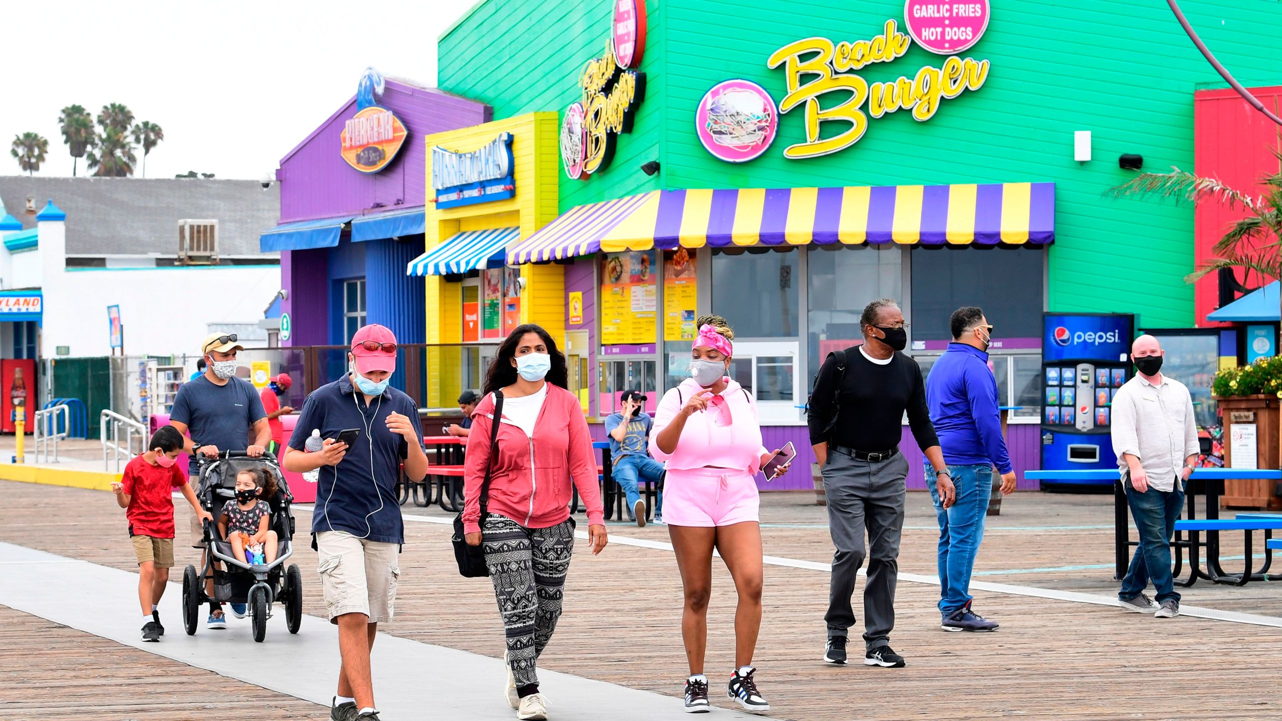 People wearing facemasks visit Santa Monica Pier after it closed for over three months due to the coronavirus pandemic, on June 26, 2020.(FREDERIC J. BROWN/AFP via Getty Images)