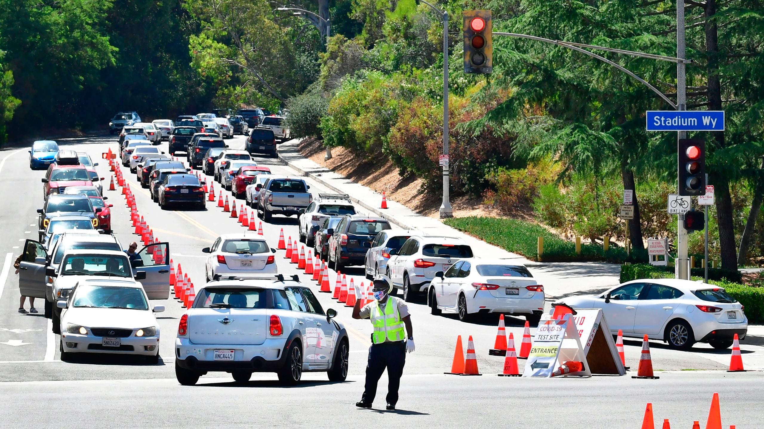 Traffic is directed at Dodger Stadium as people arrive for COVID-19 testing on June 30, 2020. (Frederic J. Brown / AFP / Getty Images)