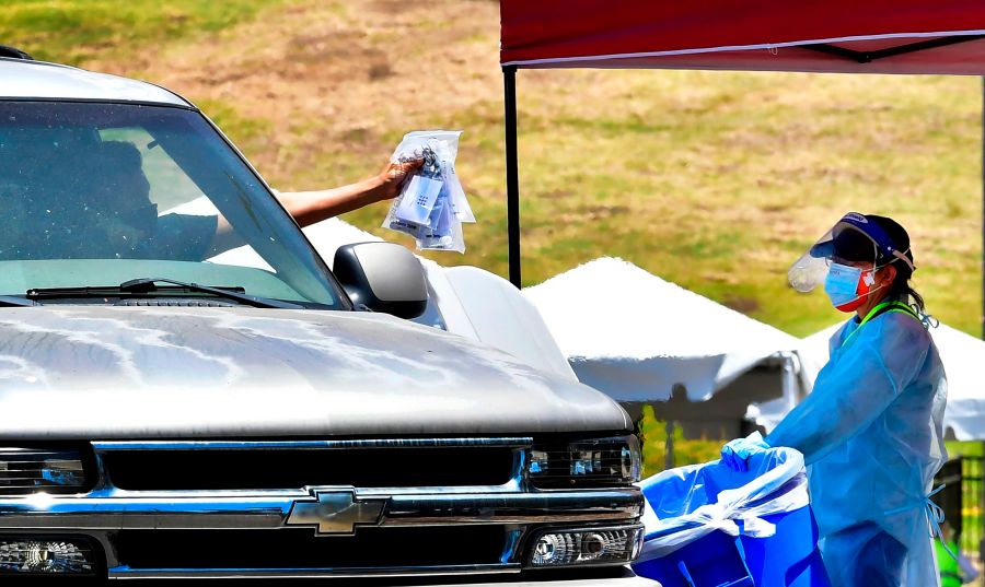 COVID-19 tests are dropped off at a drive-thru site in Los Angeles on June 30, 2020. (Frederic J. Brown / AFP / Getty Images)