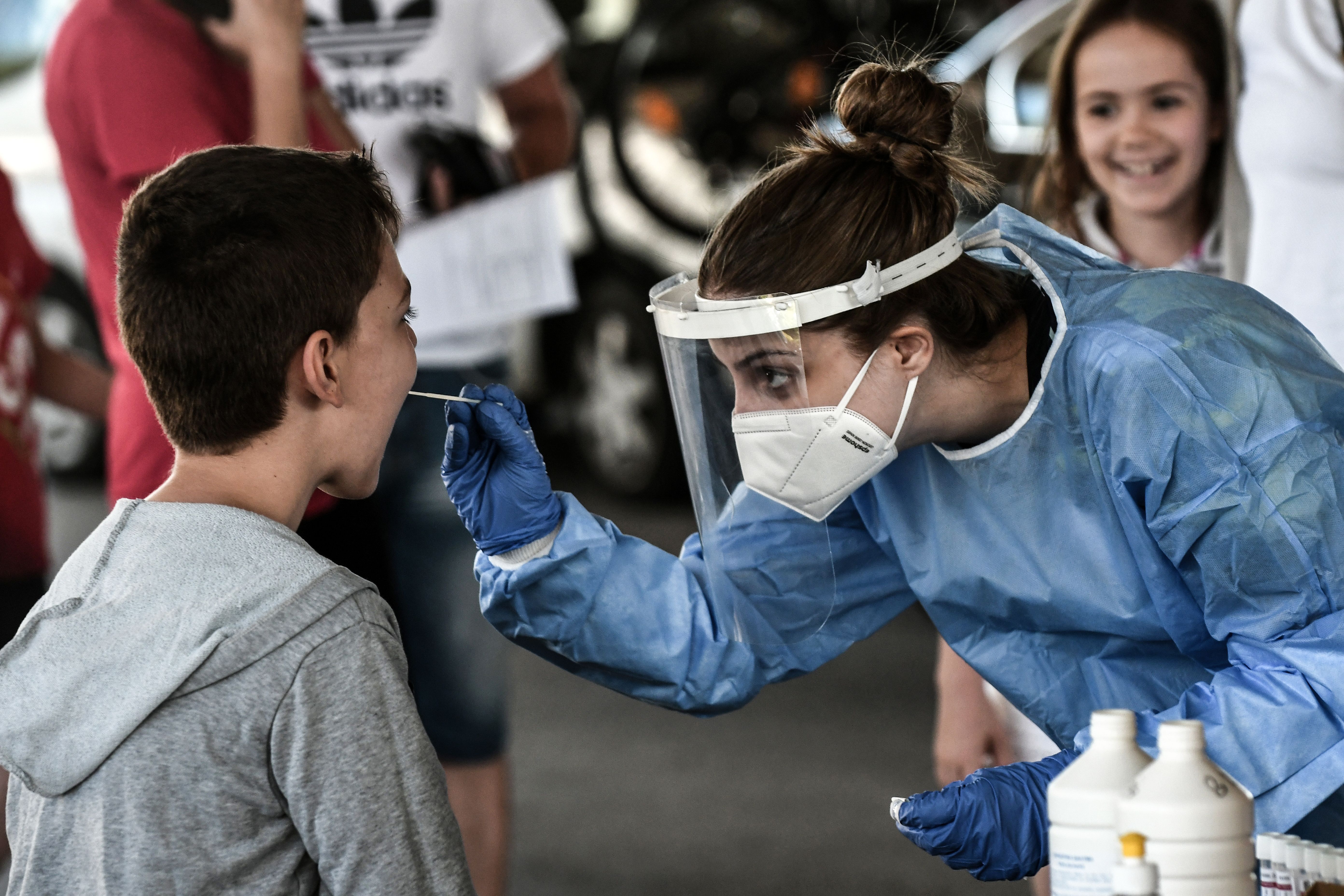 A public health worker collects a swab sample from a boy to test for the COVID-19 at the Greek-Bulgarian border crossing in Promachonas on July 10, 2020. (SAKIS MITROLIDIS/AFP via Getty Images)