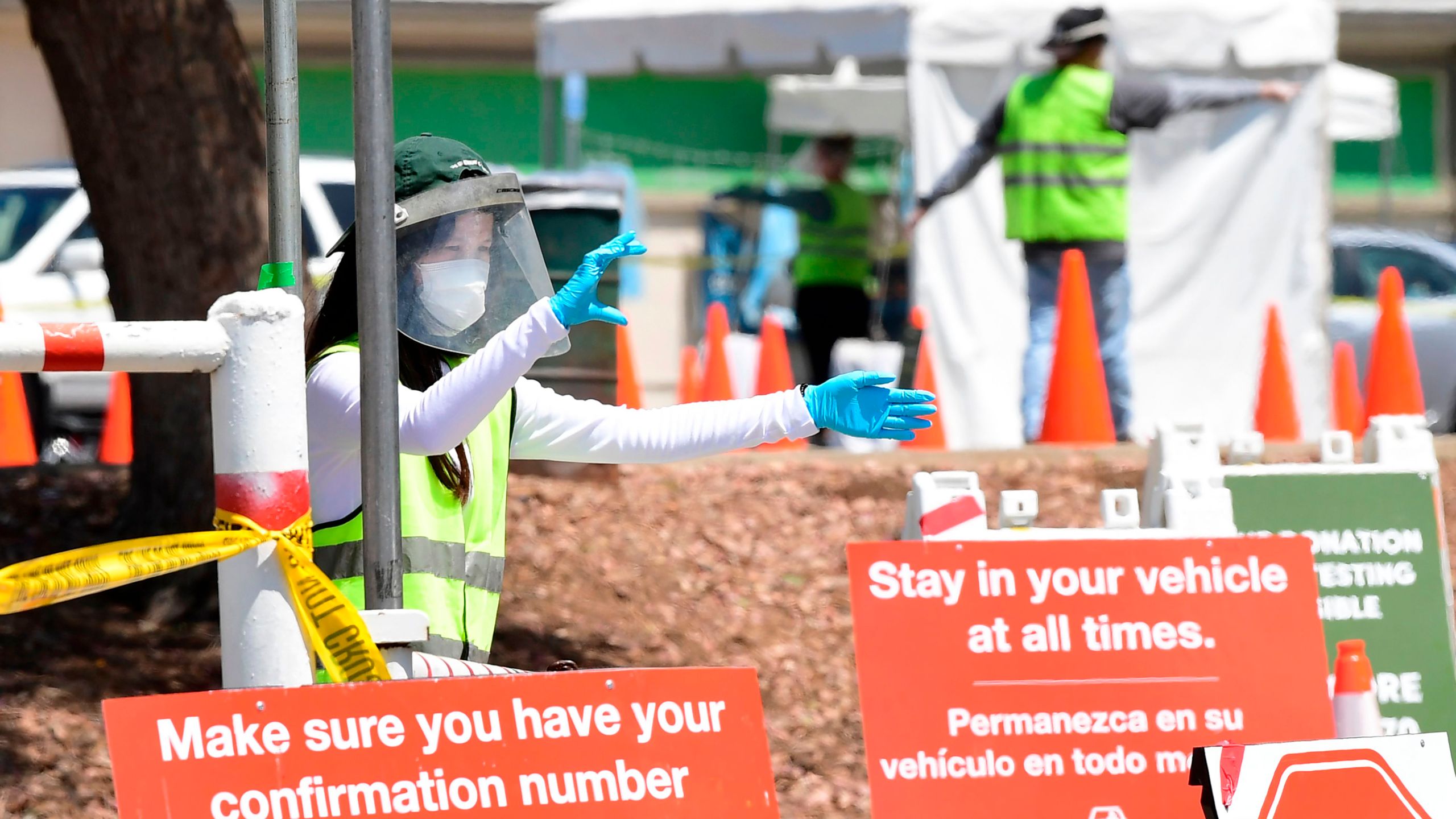 COVID-19 test site volunteers wearing personal protective equipment assist drivers arriving at a coronavirus test site in Los Angeles on July 10, 2020. (Frederic J. Brown / AFP / Getty Images)