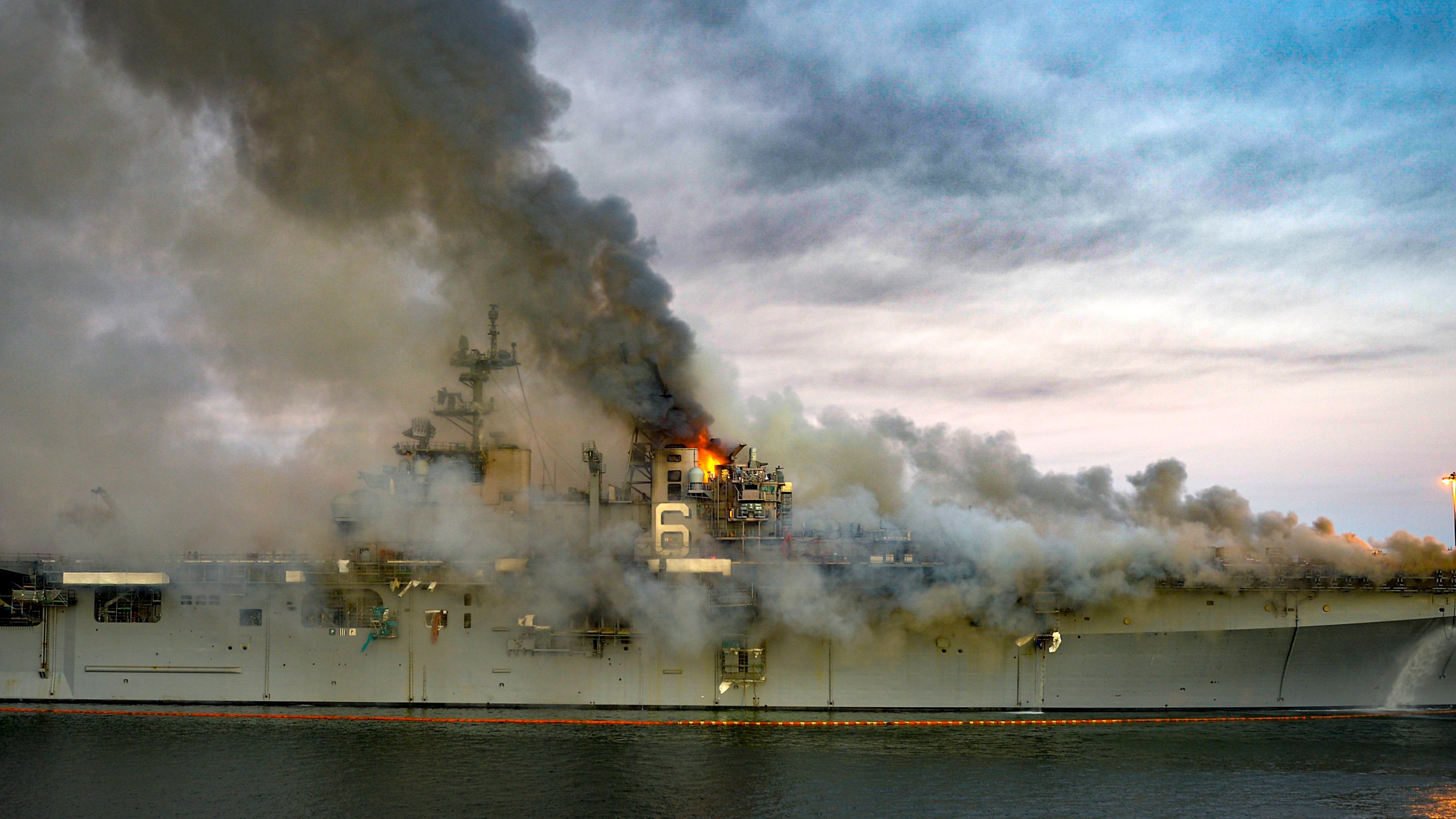 In this U.S. Navy released handout, a fire continues to be fought into the evening of July 12, 2020, on board USS Bonhomme Richard at Naval Base San Diego. (Mass Communication Specialist 2nd Class Austin Haist / U.S. Navy)