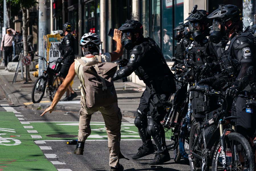 Police push a demonstrator to the ground during protests on July 25, 2020, in Seattle, Washington. (David Ryder/Getty Images)