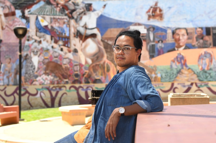 USC professor Adrian De Leon, in front of a mural in L.A.'s Filipinotown in this 2020 photo, is looking at ways the pandemic affects Americans across racial and socioeconomic lines. (Wally Skalij / Los Angeles Times)