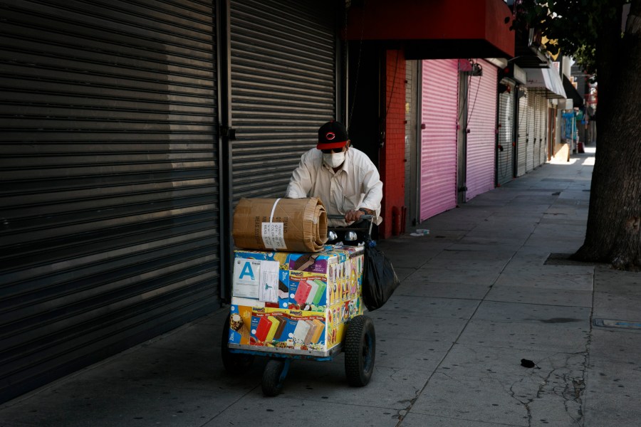 An ice cream vendor pushes his cart past shuttered stores during the coronavirus pandemic in Los Angeles on July 17, 2020. (AP Photo/Jae C. Hong)