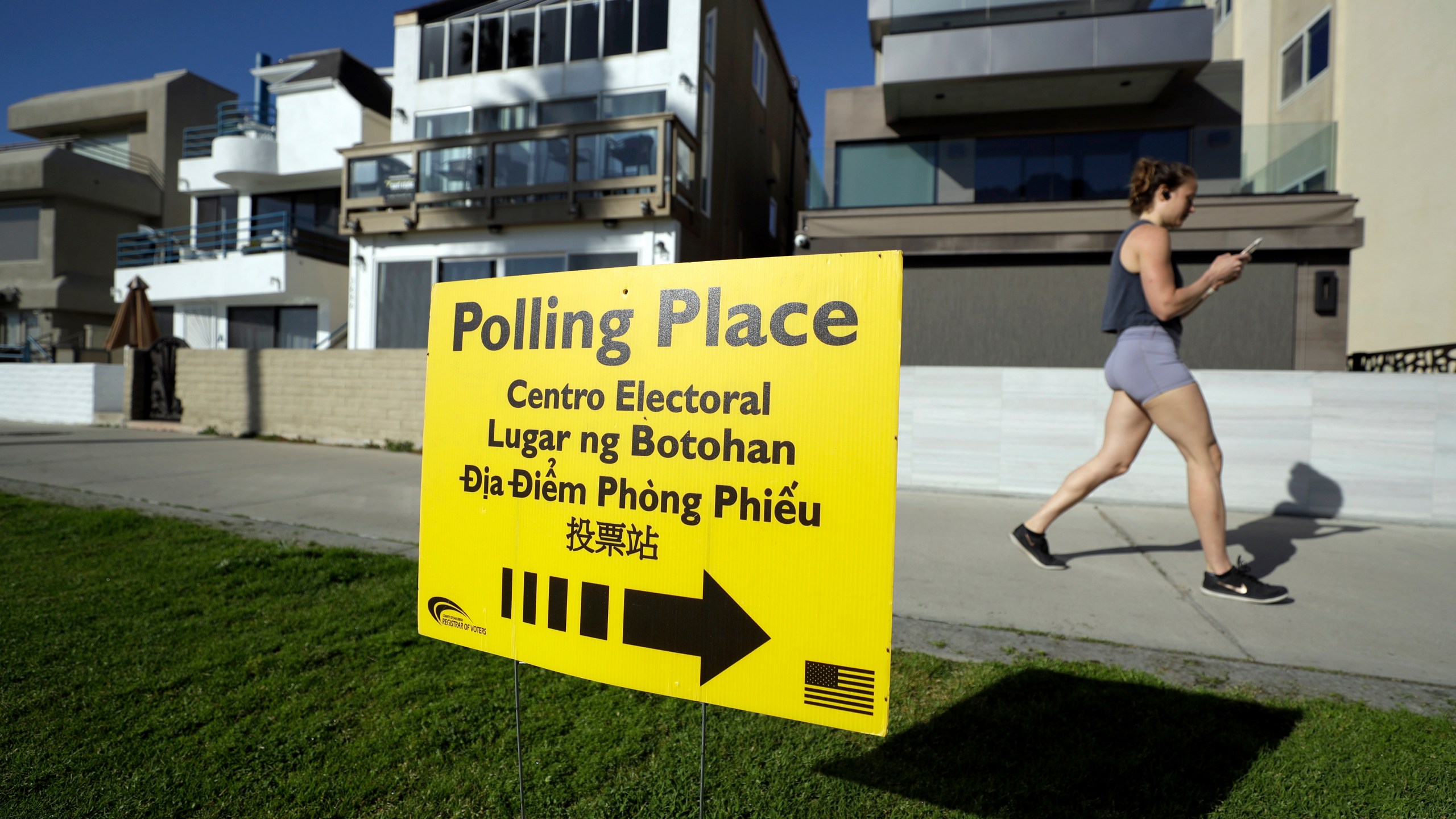 A woman runs on a path by a polling place during primary elections in San Diego on March 3, 2020. (Gregory Bull / Associated Press)