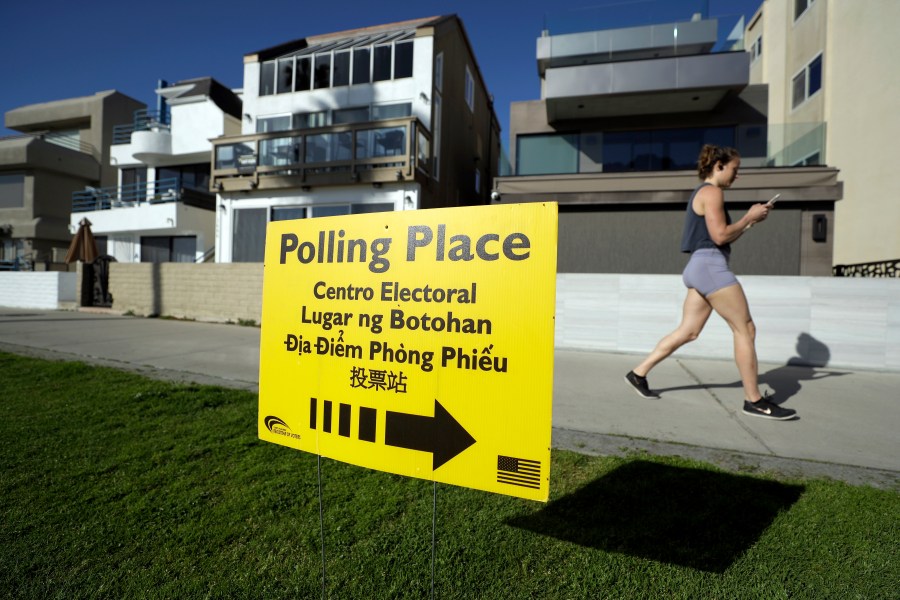 A woman runs on a path by a polling place during primary elections in San Diego on March 3, 2020. (Gregory Bull / Associated Press)