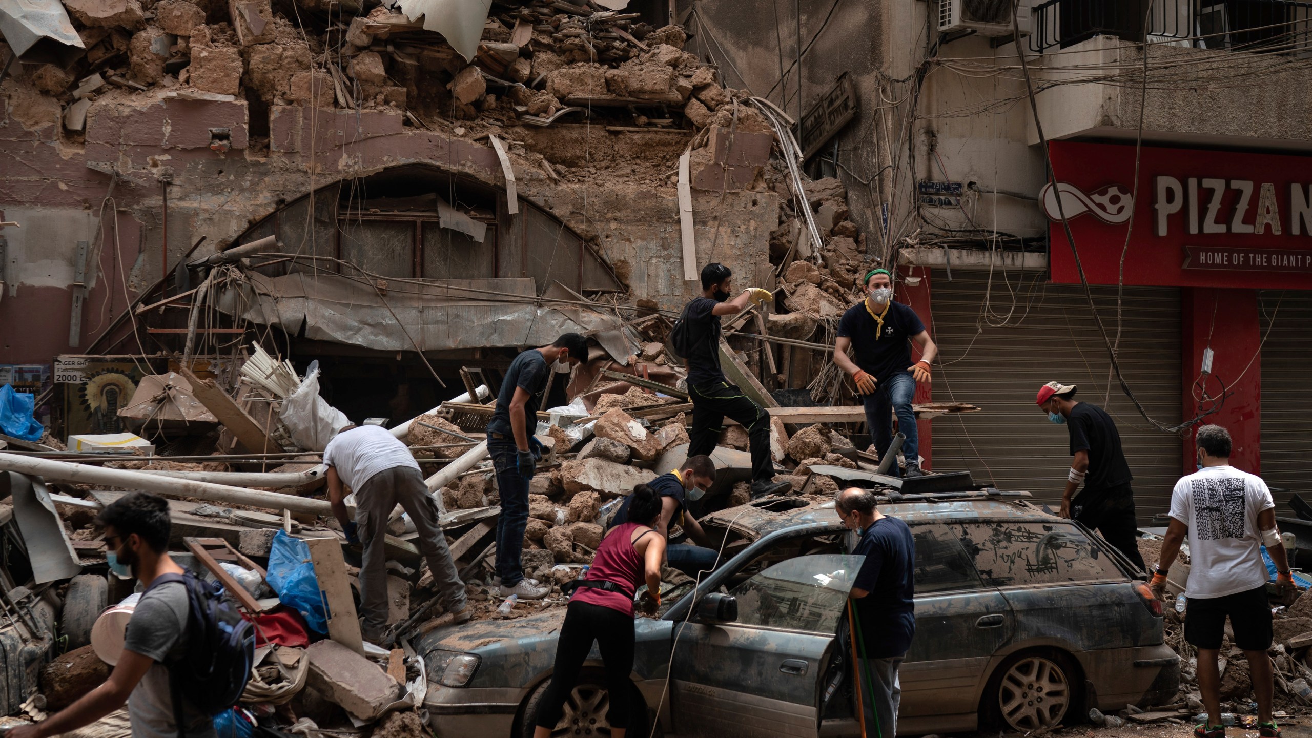 People remove debris from a house damaged by Tuesday's explosion in the seaport of Beirut, Lebanon, Friday, Aug. 7, 2020. (AP Photo/Felipe Dana)