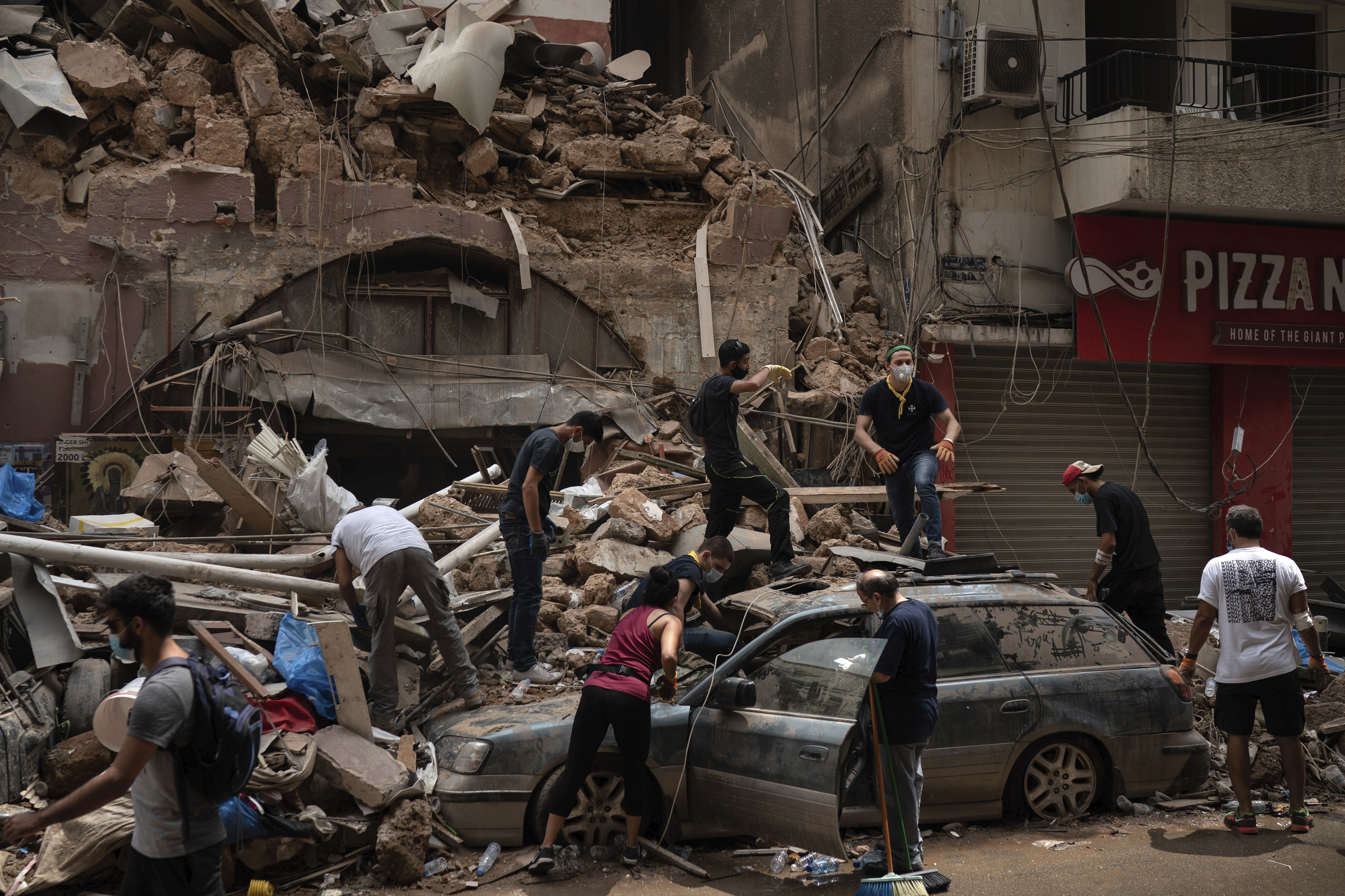 People remove debris from a house damaged by Tuesday's explosion in the seaport of Beirut, Lebanon, Friday, Aug. 7, 2020. (AP Photo/Felipe Dana)