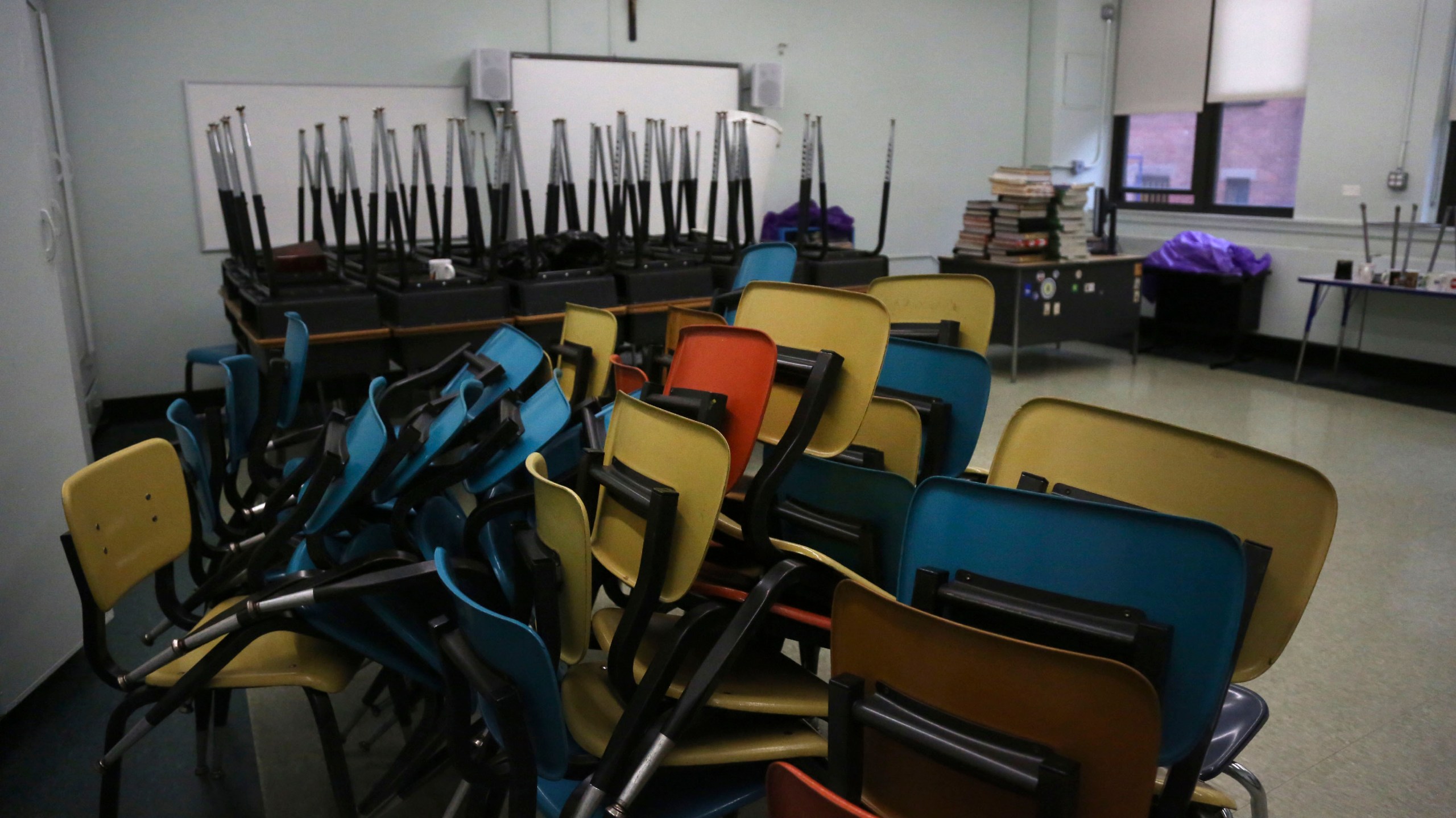 Desks are stacked in an empty classroom after the permanent closure of Queen of the Rosary Catholic Academy in Brooklyn borough of New York, Thursday, Aug. 6, 2020. (AP Photo/Jessie Wardarski)