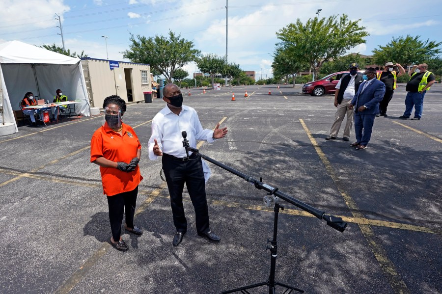 Houston Mayor Sylvester Turner, center, is joined by Rep. Sheila Jackson Lee, D-TX, left, as he speaks at a Texas Division of Emergency Management free COVID-19 testing site at Minute Maid Park Saturday, Aug. 8, 2020, in Houston. UNICEF-USA is teaming up with Turner for the organization's first-ever initiative to support kids in the U.S. (AP Photo/David J. Phillip)