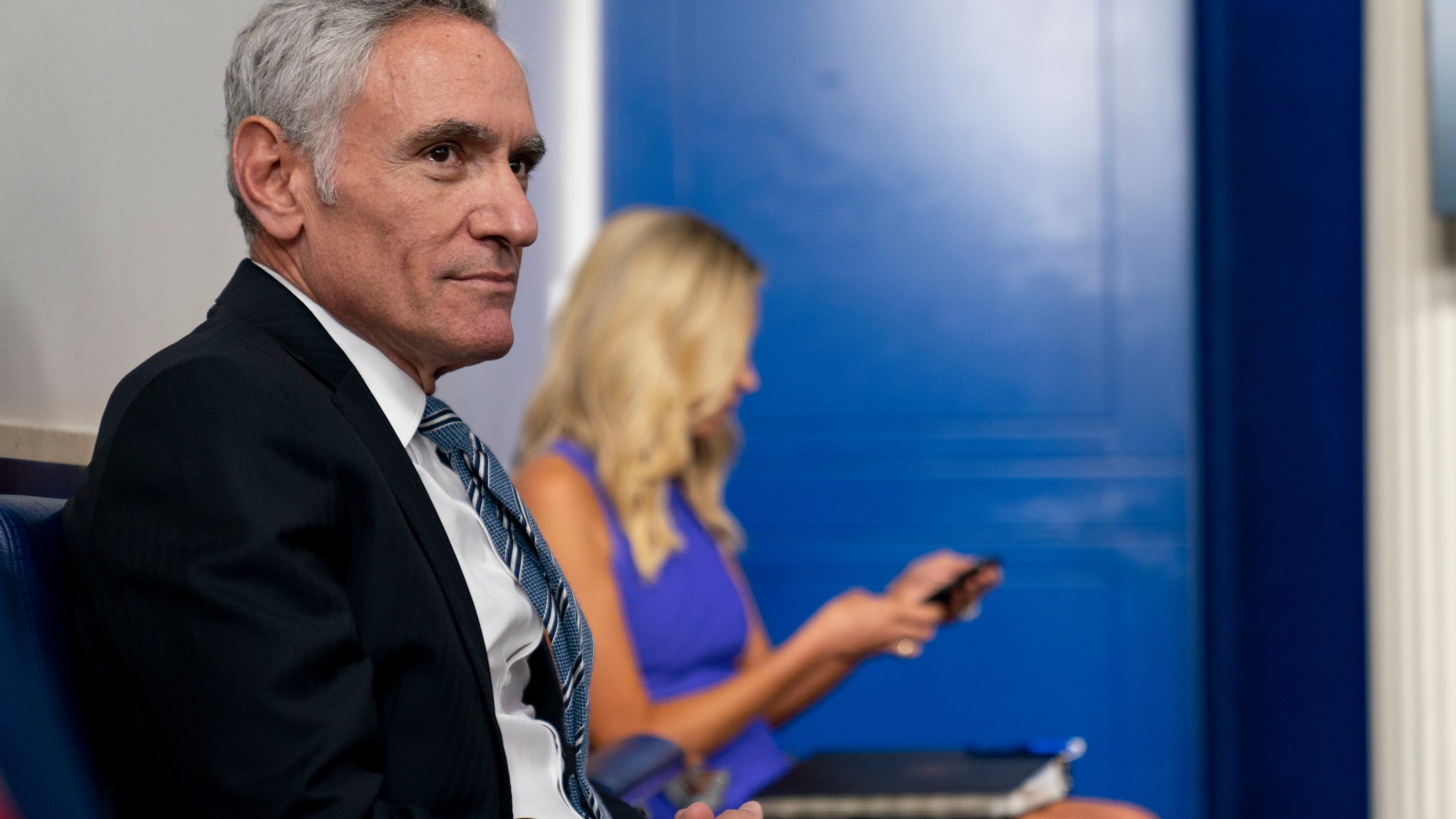 In this Aug. 12, 2020, file photo Scott Atlas, senior fellow at the Hoover Institution, left, and White House press secretary Kayleigh McEnany, right, arrive ahead of President Donald Trump for a news conference at the White House in Washington. (AP Photo/Andrew Harnik, File)