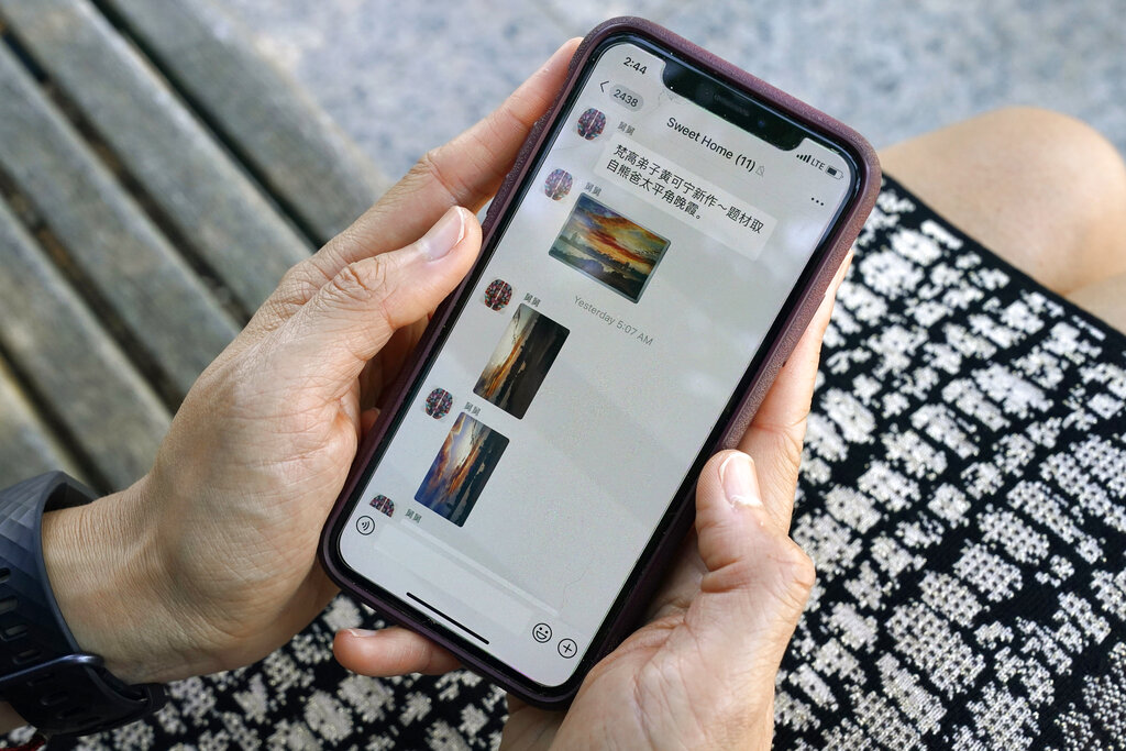 Sha Zhu, of Washington, shows the app WeChat on her phone, which she uses to keep in touch with family and friends in the U.S. and China, on Aug. 18, 2020, in Washington. (AP Photo/Jacquelyn Martin)