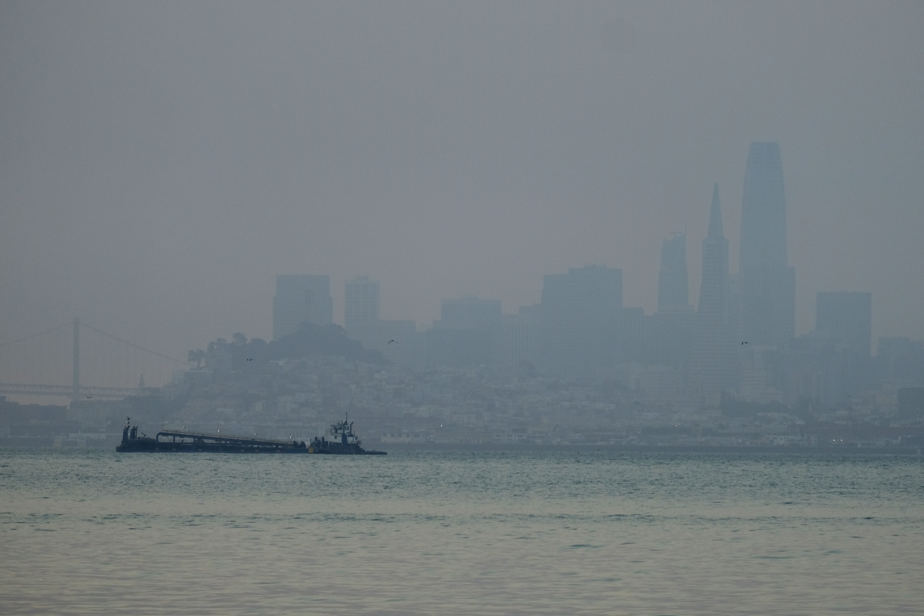 The San Francisco skyline is barely visible through smoke from wildfires Wednesday, Aug. 19, 2020, in this view from Sausalito, Calif. Thousands of people were under orders to evacuate in regions surrounding the San Francisco Bay Area Wednesday as nearly 40 wildfires blazed across the state amid a blistering heat wave now in its second week. Smoke blanketed the city of San Francisco. (AP Photo/Eric Risberg)