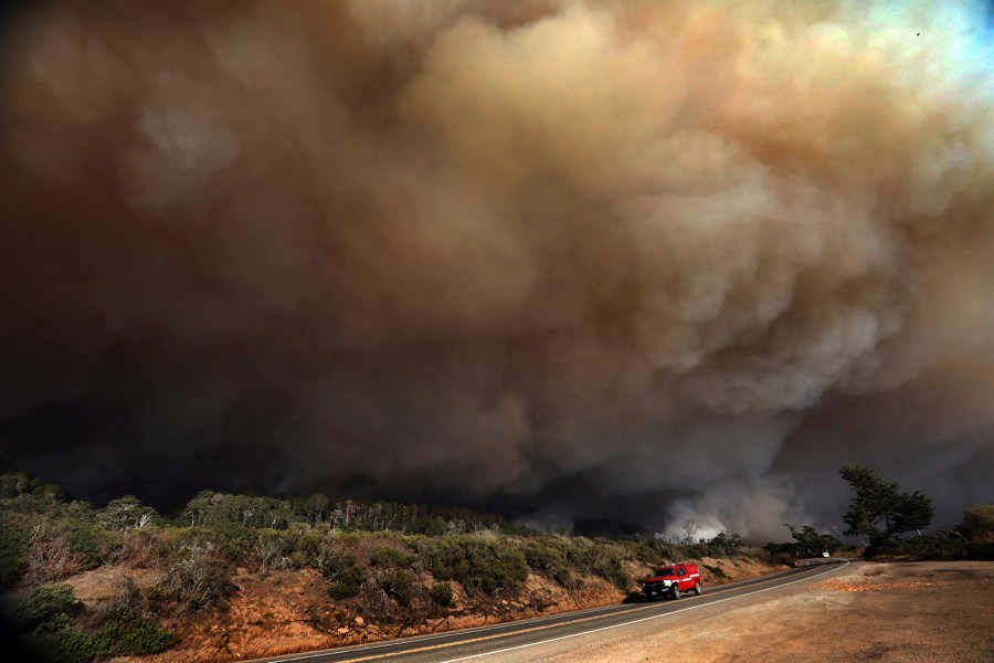 A massive column of smoke rises above Highway 1 just north of the Santa Cruz County line as a section of the CZU August Lightning Complex burns above Waddell Beach, on Aug. 19, 2020, northwest of Santa Cruz, Calif. (Shmuel Thaler/The Santa Cruz Sentinel via AP)