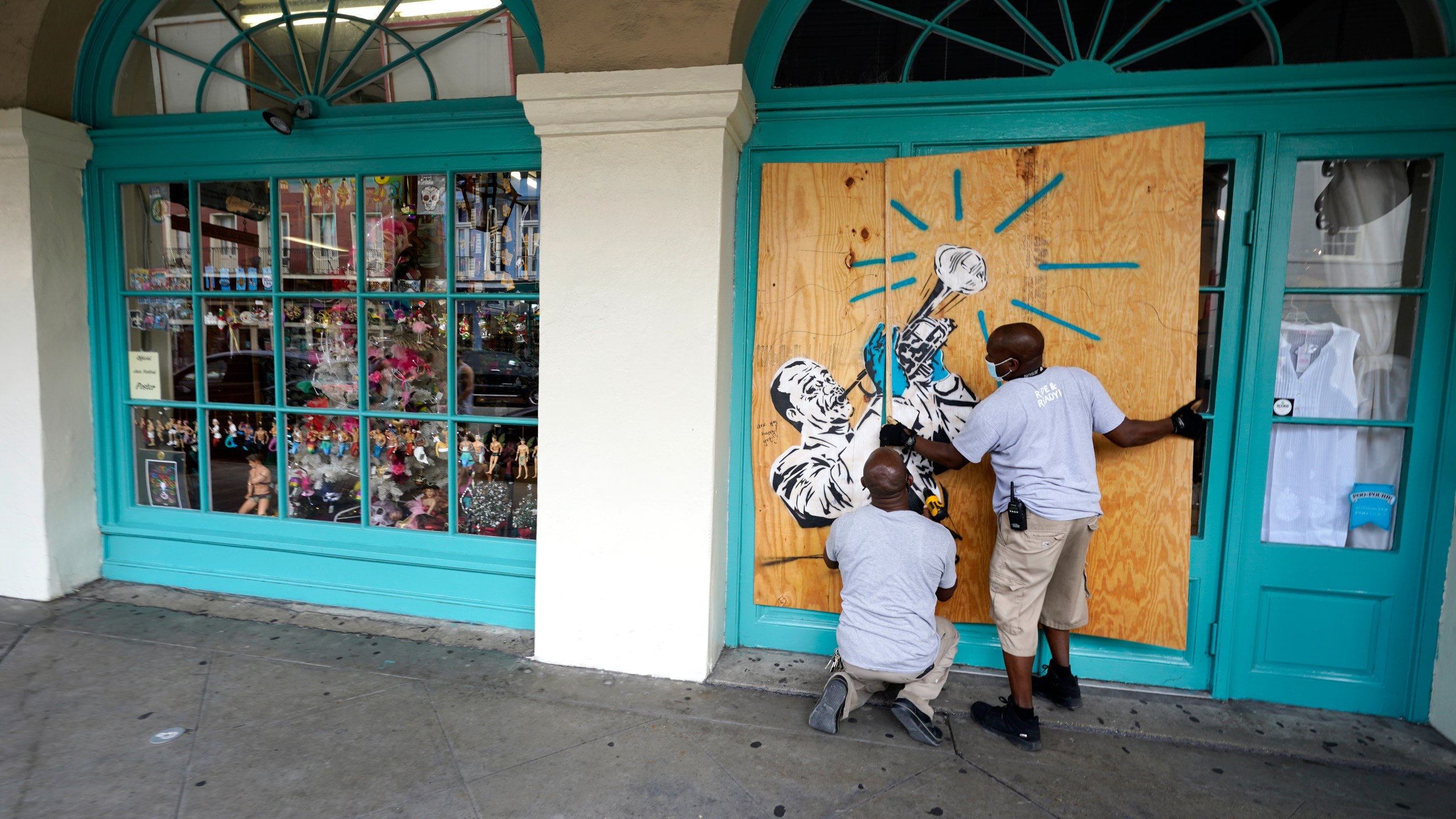 Workers board up shops in the French Quarter of New Orleans, on Aug. 23, 2020, in advance of Hurricane Marco, expected to make landfall on the Southern Louisiana coast. (AP Photo/Gerald Herbert)