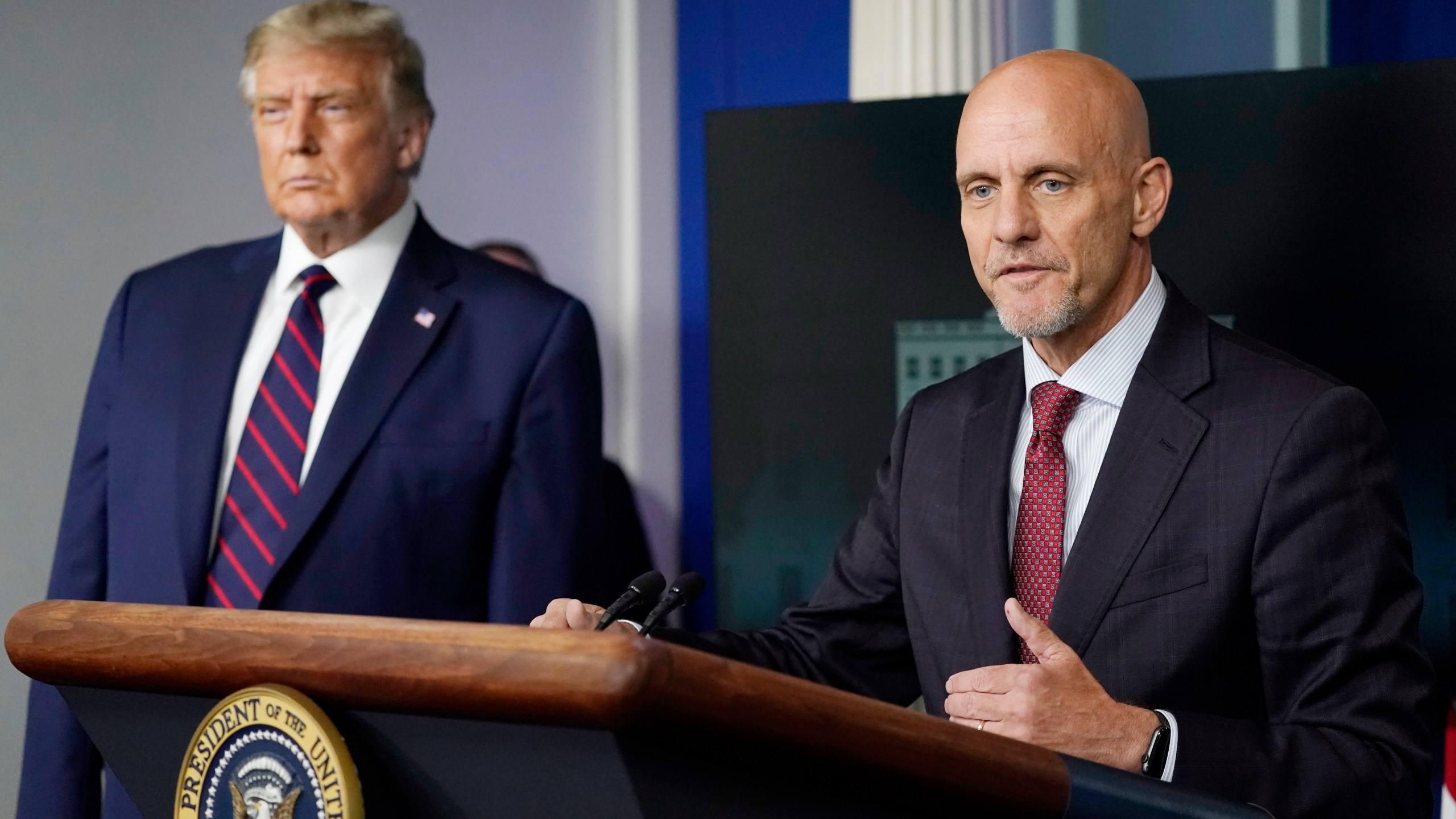 Donald Trump listens as Dr. Stephen Hahn, commissioner of the U.S. Food and Drug Administration, speaks during a media briefing in the James Brady Briefing Room of the White House, Sunday, Aug. 23, 2020, in Washington. (AP Photo/Alex Brandon)