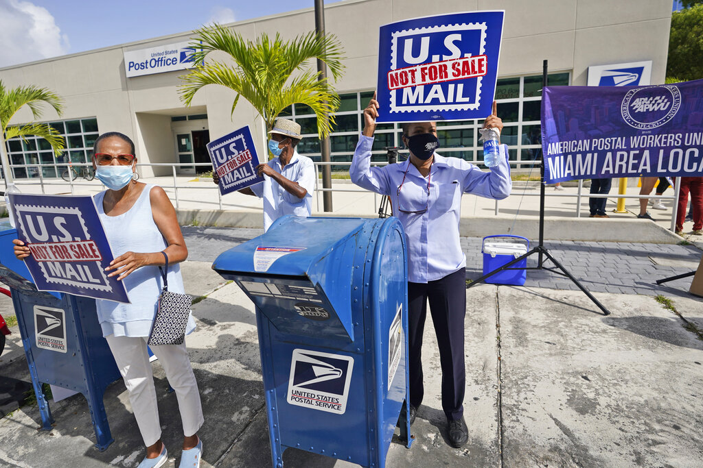 Protesters demonstrate during a "National Day of Action to Save the "Peoples" Post Office!" outside the Flagler Station post office, Tuesday, Aug. 25, 2020, in Miami. (AP Photo/Wilfredo Lee)