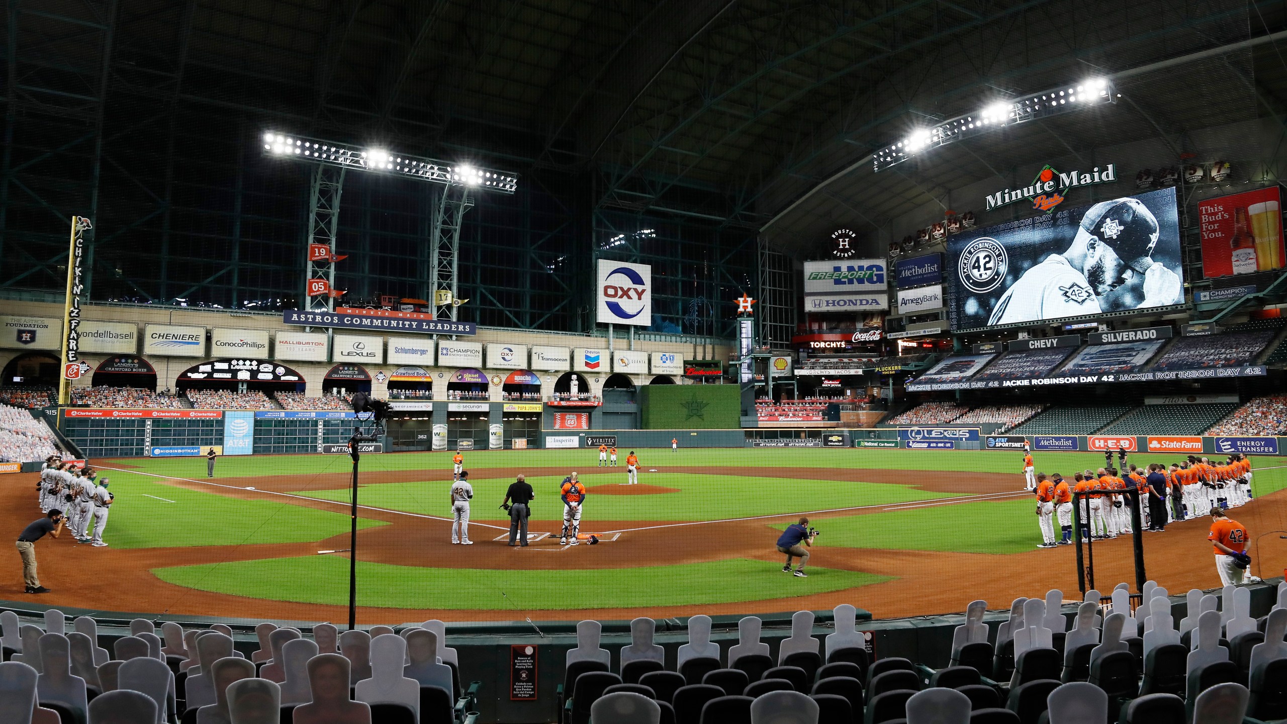 The Oakland Athletics and the Houston Astros stand together in a moment of silence before leaving the field without playing their scheduled baseball game in a protest of racial injustice on Aug. 28, 2020, in Houston. (Kevin M. Cox/The Galveston County Daily News via AP)