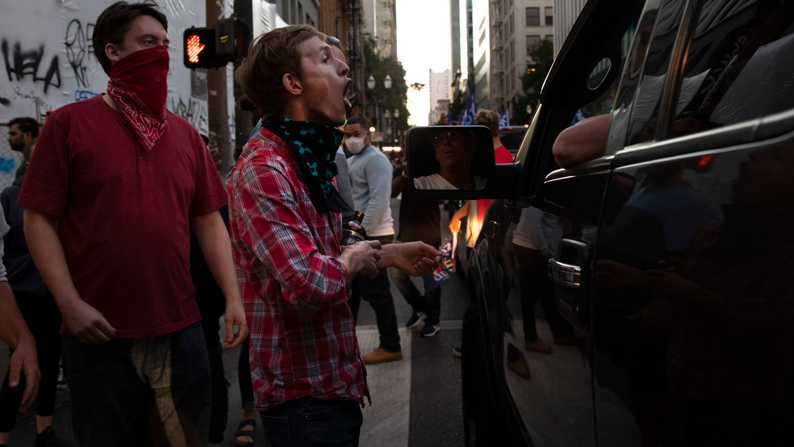 A Black Lives Matter protester yells at a supporter of President Donald Trump during a rally and car parade Saturday, Aug. 29, 2020, in Portland, Ore. (AP Photo/Paula Bronstein)