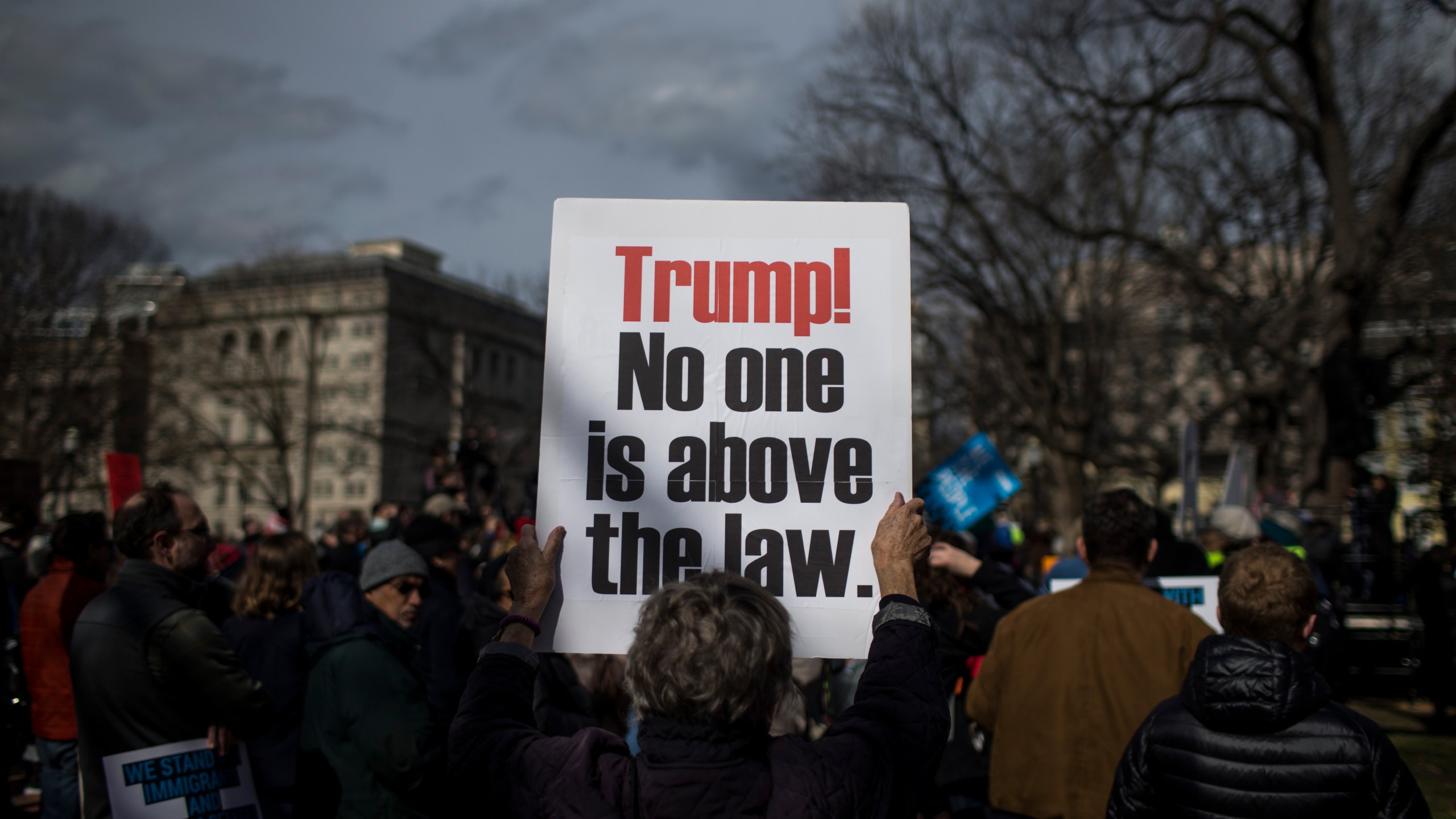 A demonstrator holds a sign in Lafayette Square during a demonstration organized by the American Civil Liberties Union (ACLU) protesting President Donald Trump's declaration of emergency powers on Feb. 18, 2019, in Washington, D.C. (Zach Gibson/Getty Images)