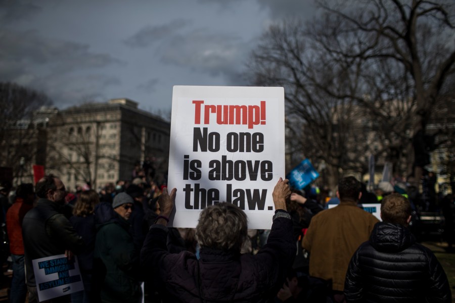 A demonstrator holds a sign in Lafayette Square during a demonstration organized by the American Civil Liberties Union (ACLU) protesting President Donald Trump's declaration of emergency powers on Feb. 18, 2019, in Washington, D.C. (Zach Gibson/Getty Images)