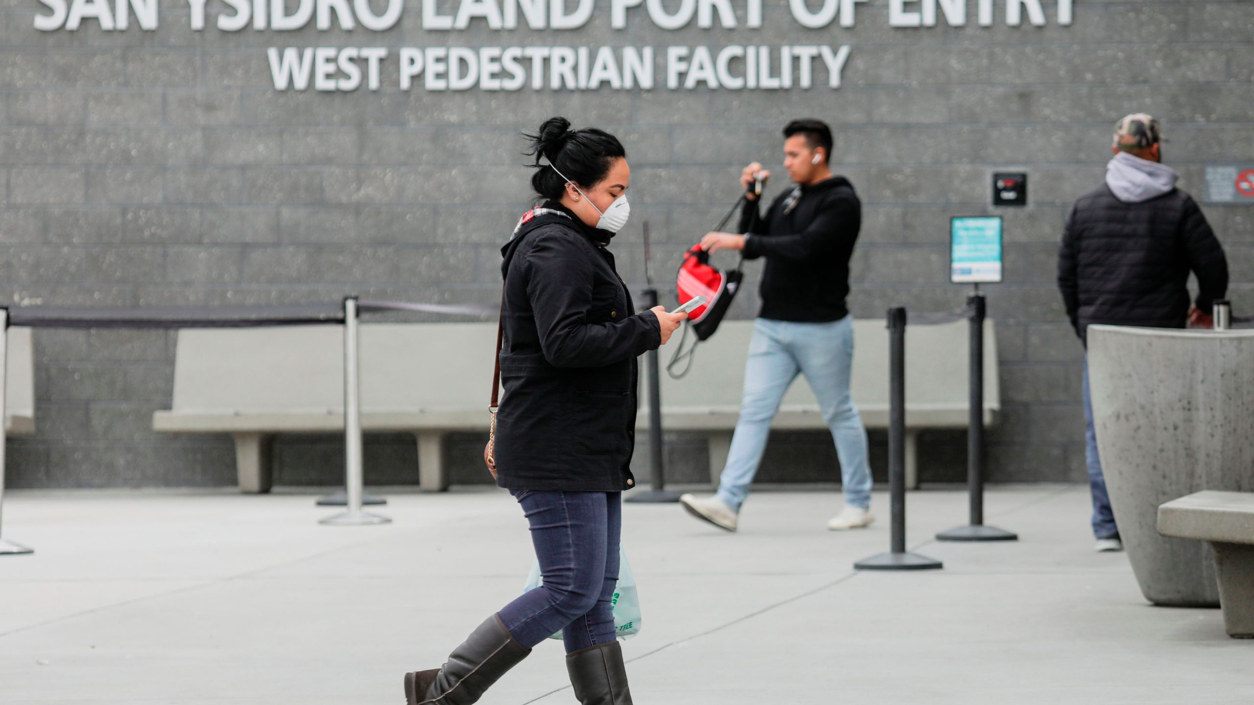 Pedestrians walk out of the United States Port of Entry after coming from Mexico in San Ysidro on March 20, 2020. (SANDY HUFFAKER/AFP via Getty Images)