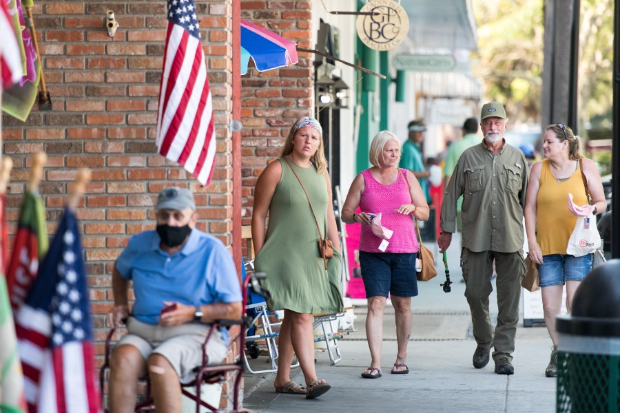 People walk down the sidewalk on July 17, 2020, in St. Simons Island, Georgia. Georgia Gov. Brian Kemp made an order earlier in the week that forbade municipal officials from setting mandatory face-covering policies. (Sean Rayford/Getty Images)