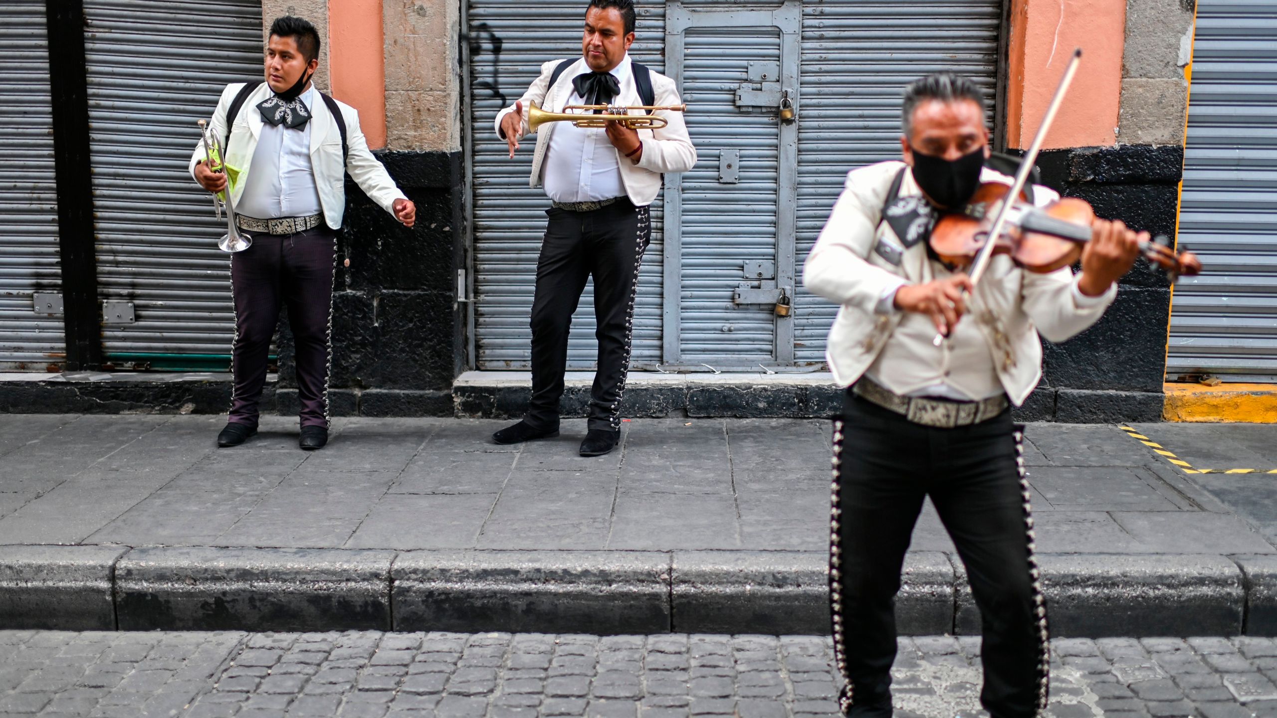 Mariachi wear face masks as they perform on the street to earn some money due to the lack of work amid the COVID-19 novel coronavirus pandemic, in Mexico City on Aug. 7, 2020. (PEDRO PARDO/AFP via Getty Images)