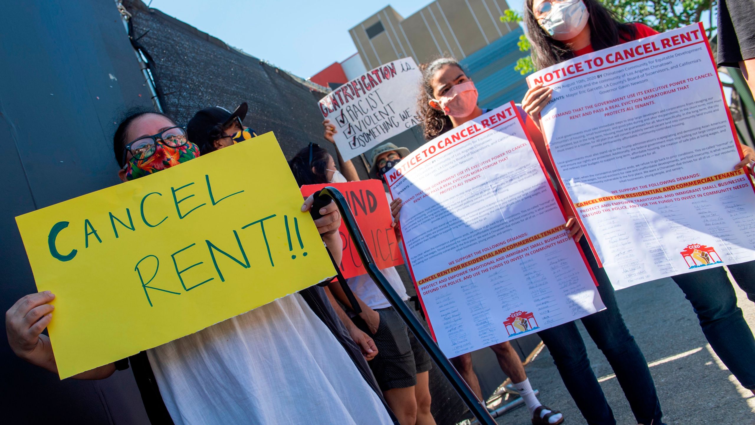 Ady Carrillo, left, holds a sign asking to "Cancel Rent" during the "Cancel Rent" Protest and Caravan in Chinatown, Aug. 10 2020, in Los Angeles. (VALERIE MACON/AFP via Getty Images)