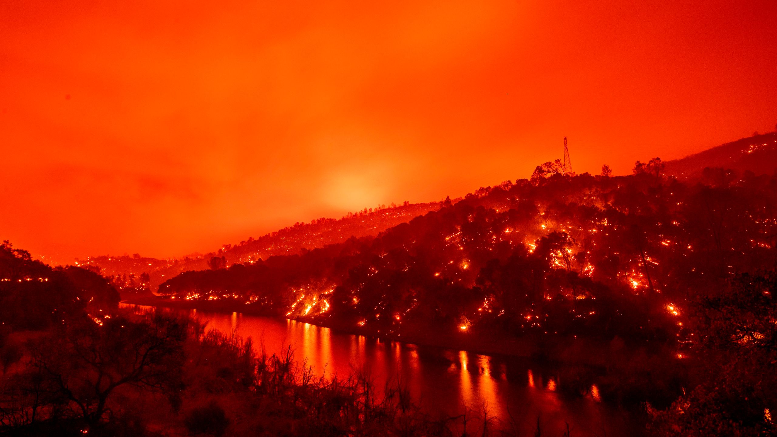 In this long exposure photograph, flames set ablaze both sides of a segment of Lake Berryessa during the Hennessey fire in the Spanish Flat area of Napa on Aug. 18, 2020. (JOSH EDELSON/AFP via Getty Images)