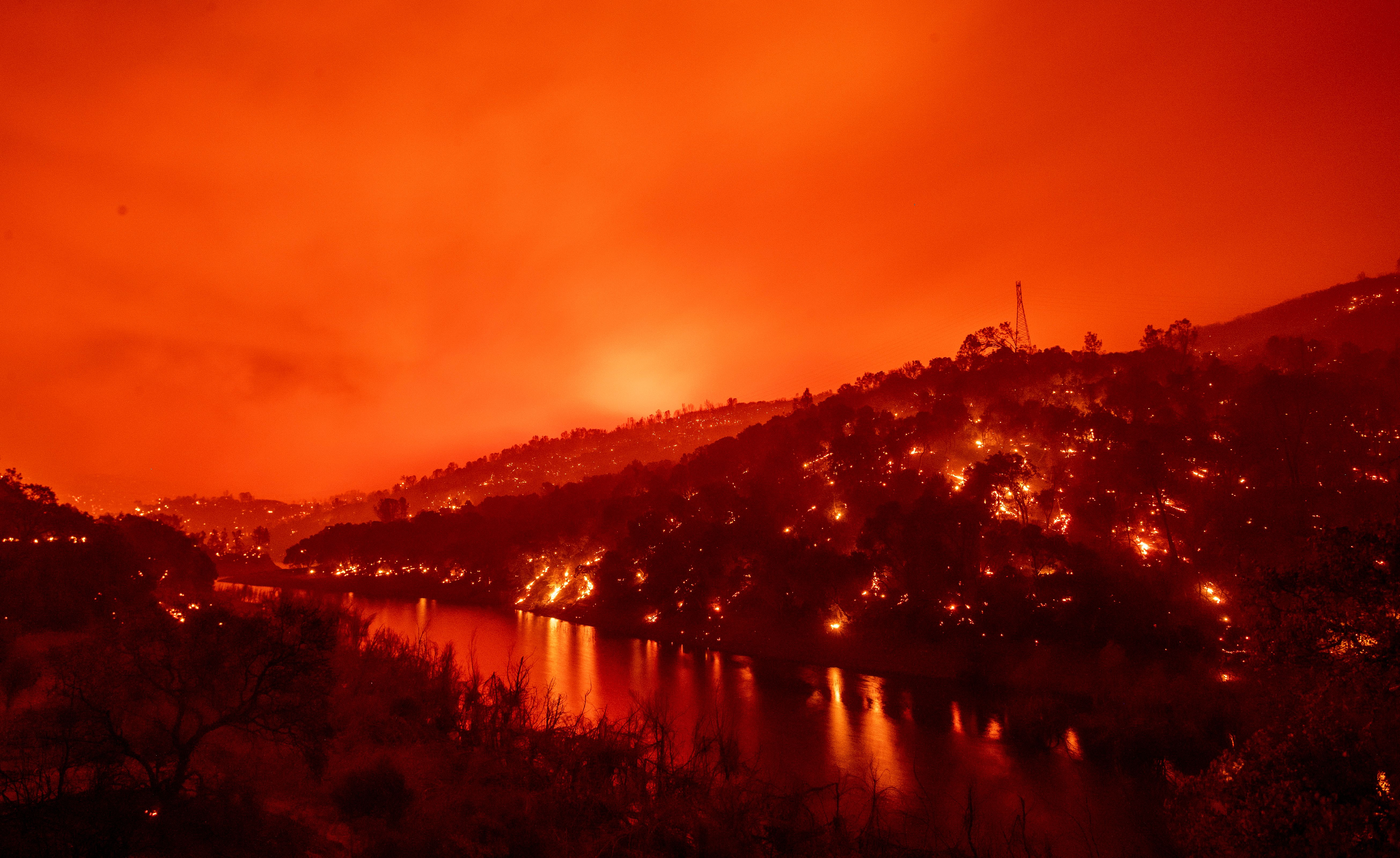 In this long exposure photograph, flames set ablaze both sides of a segment of Lake Berryessa during the Hennessey fire in the Spanish Flat area of Napa on Aug. 18, 2020. (JOSH EDELSON/AFP via Getty Images)