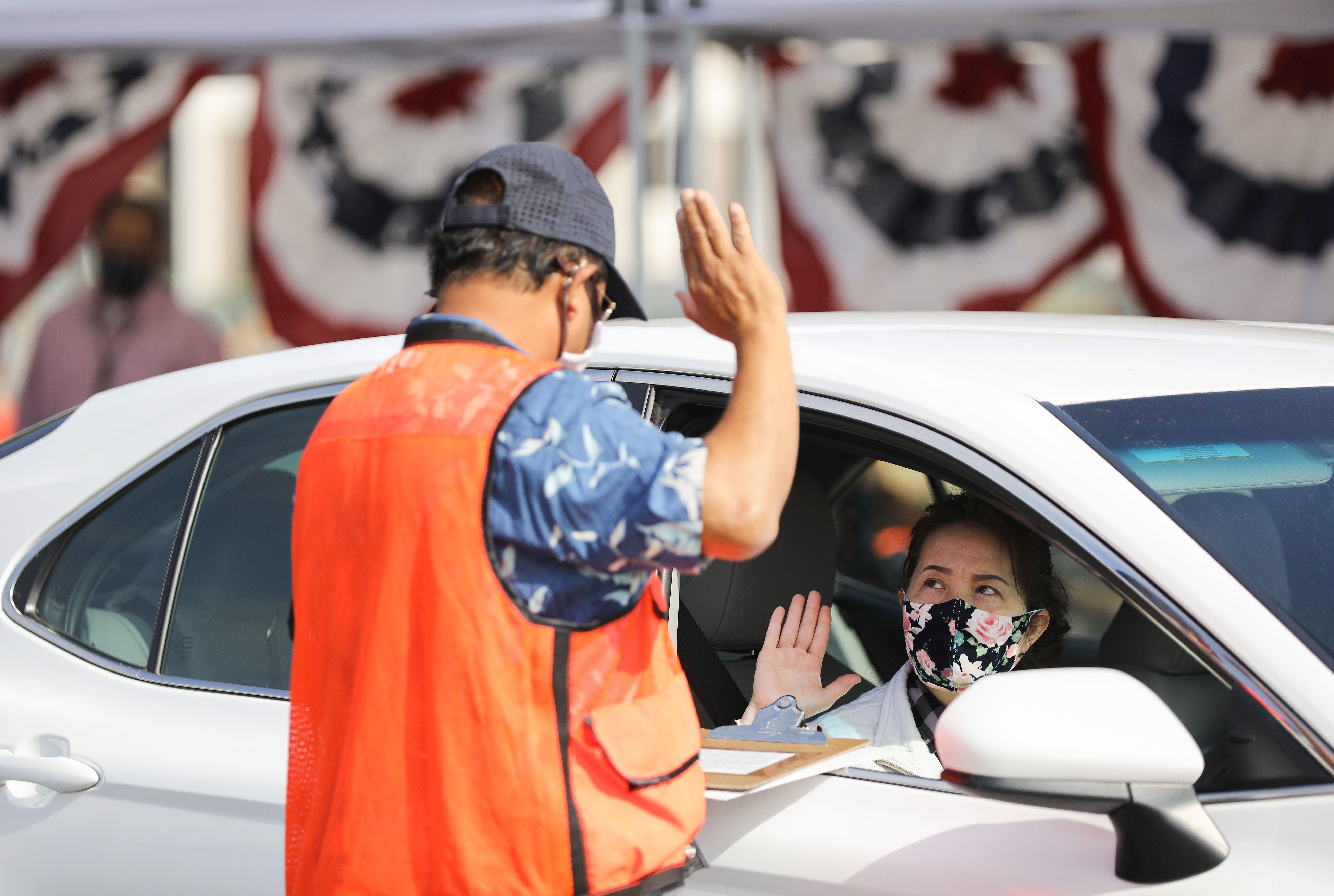 A woman is sworn in as a new U.S. citizen from inside a vehicle at a drive-in naturalization ceremony conducted amid the COVID-19 pandemic on July 29, 2020 in Santa Ana. (Mario Tama/Getty Images)