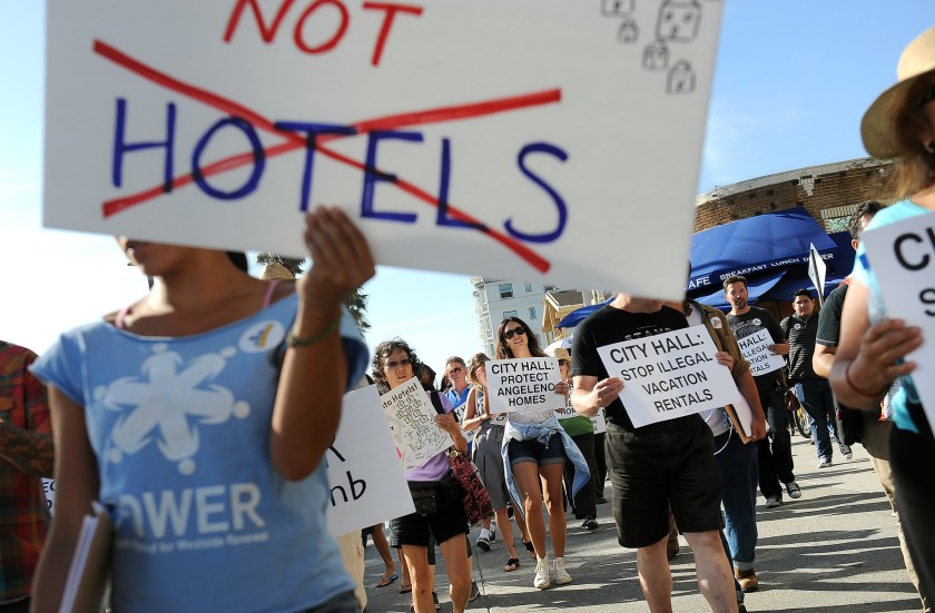 Dozens of Venice residents and advocates rally on the Venice Boardwalk in 2015 to call on the Los Angeles City Council to regulate short-term rentals.(Christina House / Los Angeles Times)