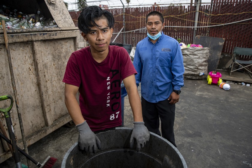 Gadseel Quiñonez, 29, right, and his brother Jose Quiñonez, 18, at the recycling center where they work in this 2020 photo. (Brian van der Brug / Los Angeles Times)