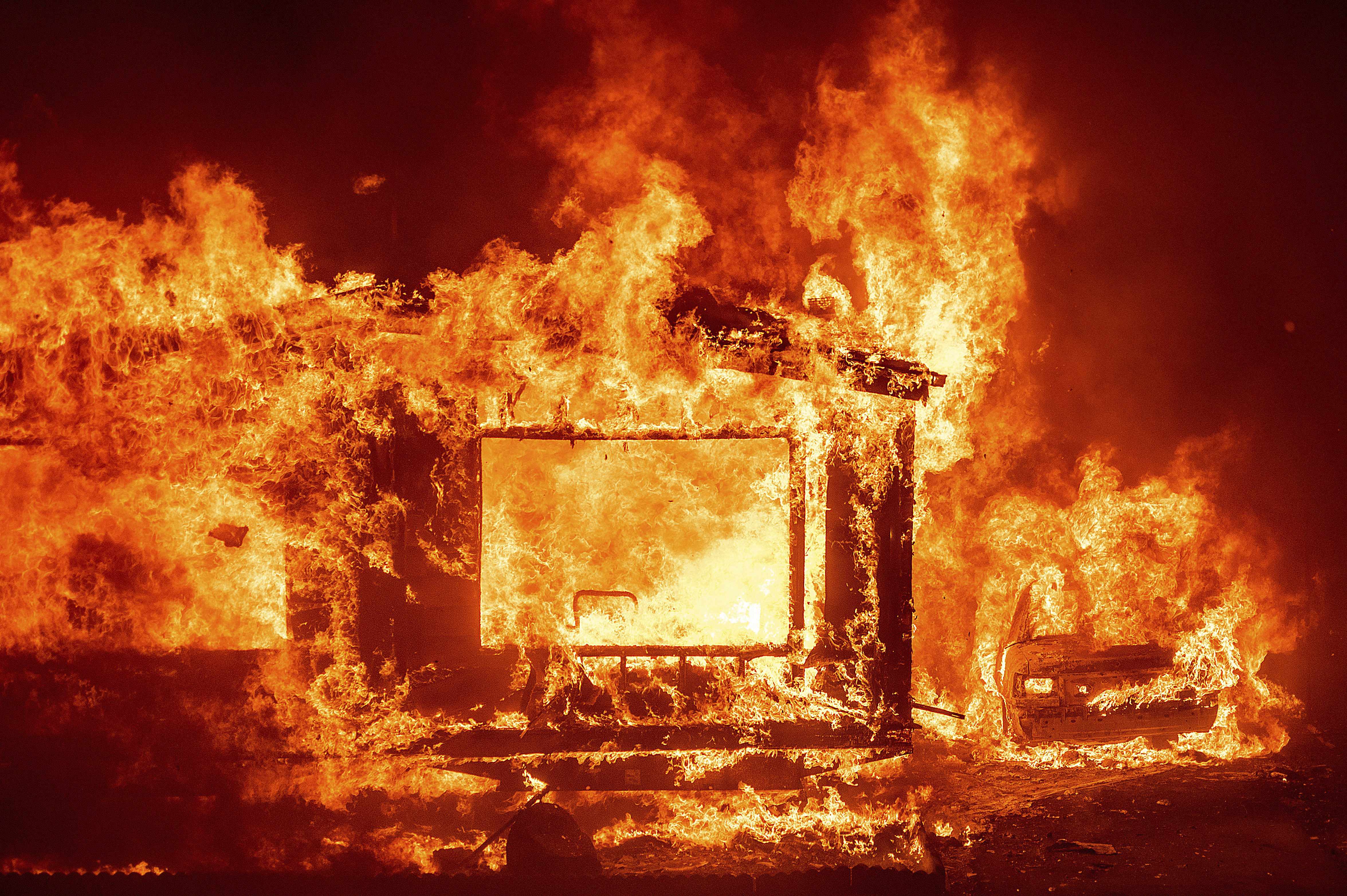 A mobile home and car burn at Spanish Flat Mobile Villa as the LNU Lightning Complex fires tear through unincorporated Napa County, California. (Noah Berger/AP via CNN Wire)